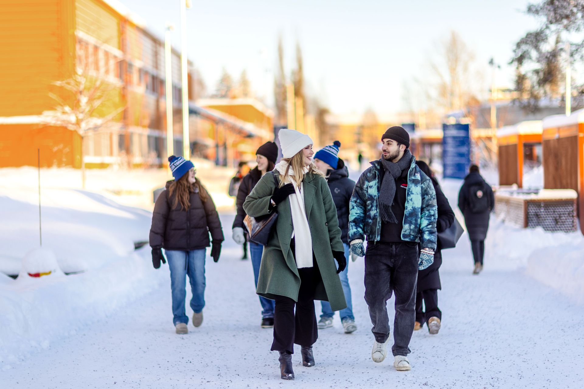 A group of students at Luleå Institute of Technology walk along a snowy road.