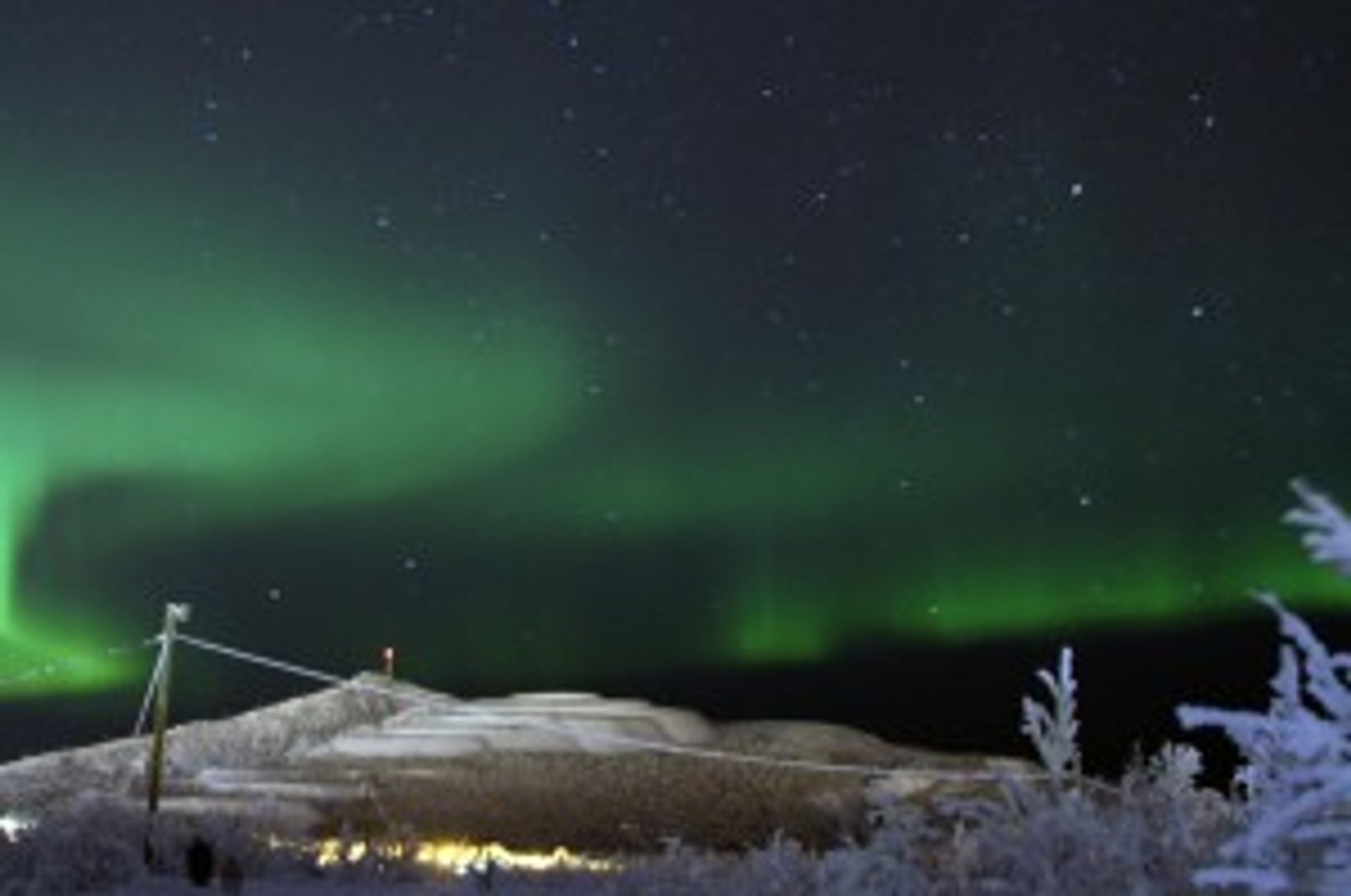 A picture of the green northern lights that often occur in the northern part of Sweden by mountains.