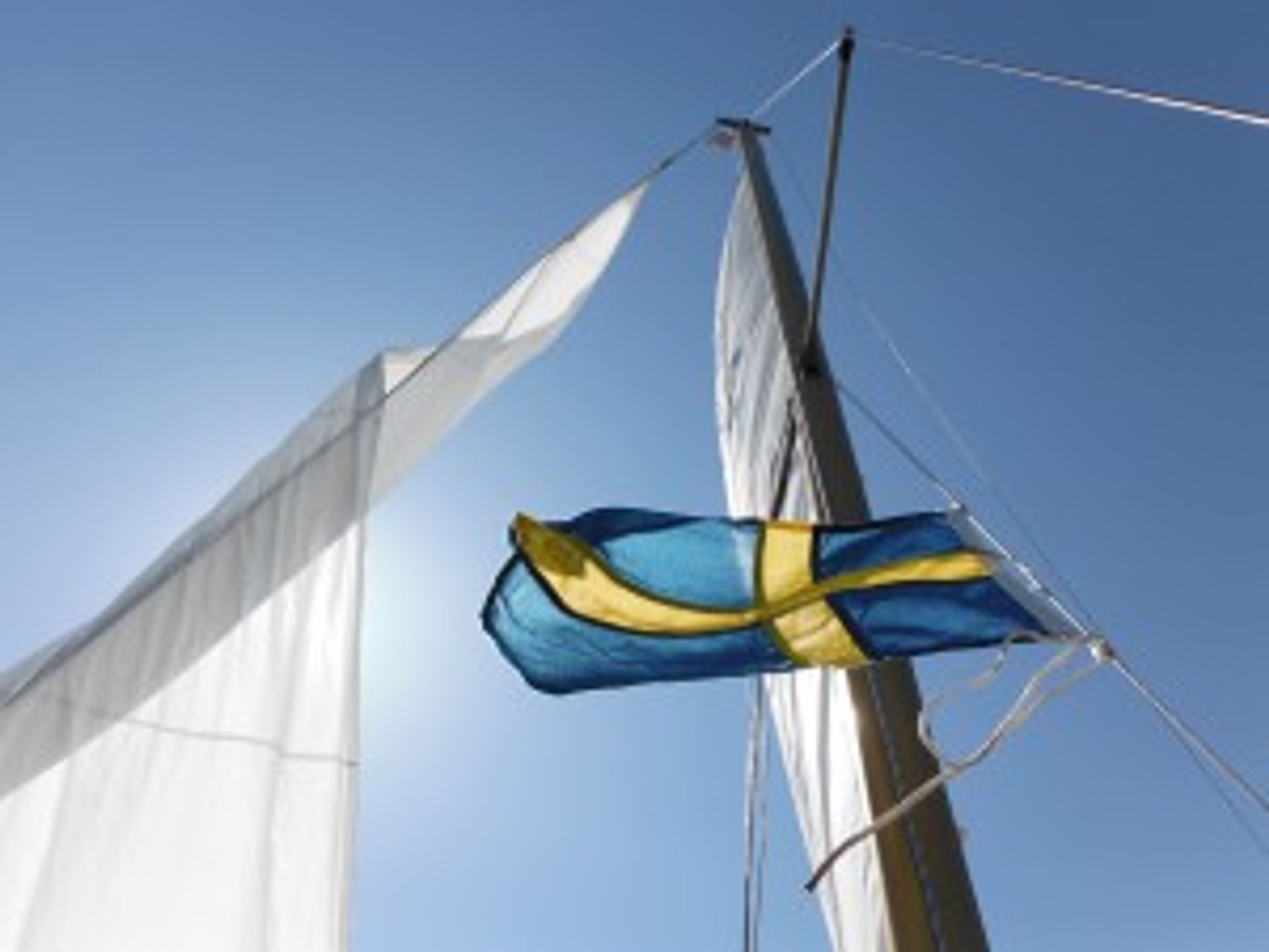 A Swedish flag flying on a ship's mast.