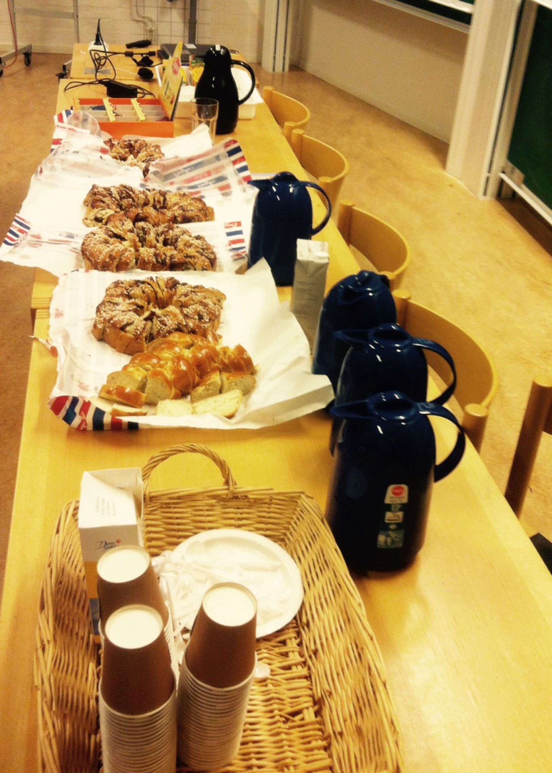 A table full of fika such as cinnamon buns, cinnamon length on butter, tea and coffee.