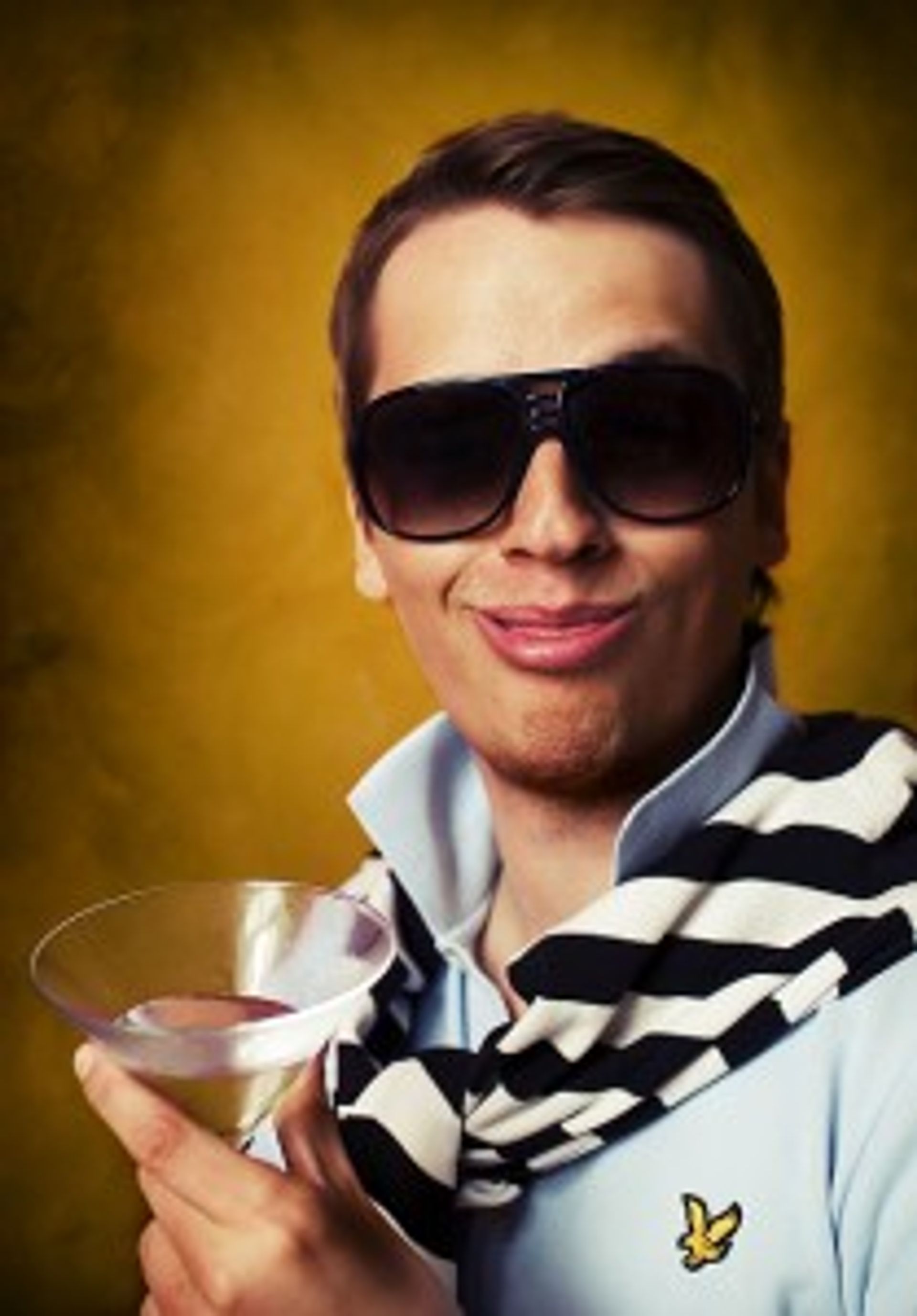 Man wearing sunglasses and holding a martini glass.