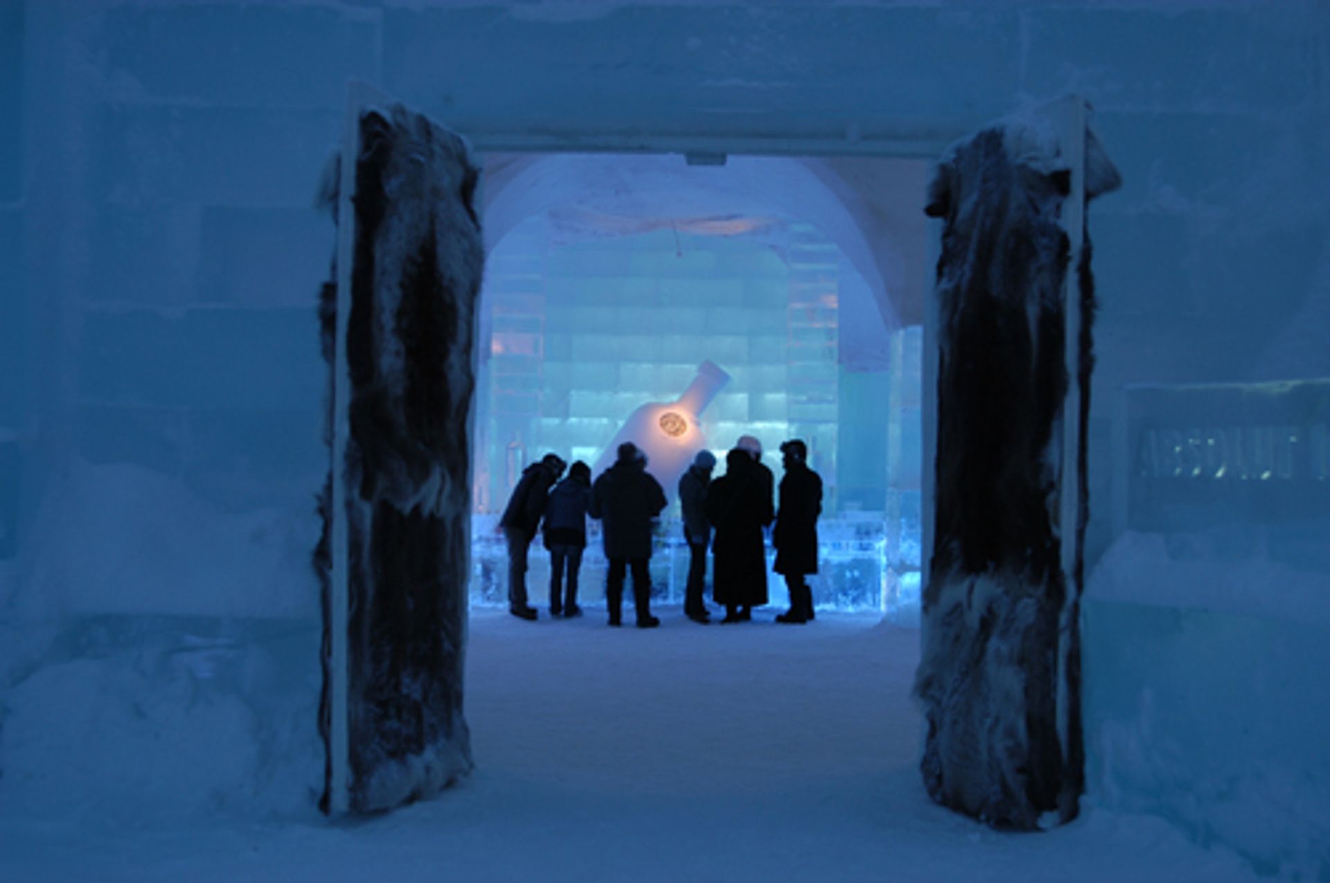 A group of people stand inside the Ice Hotel.