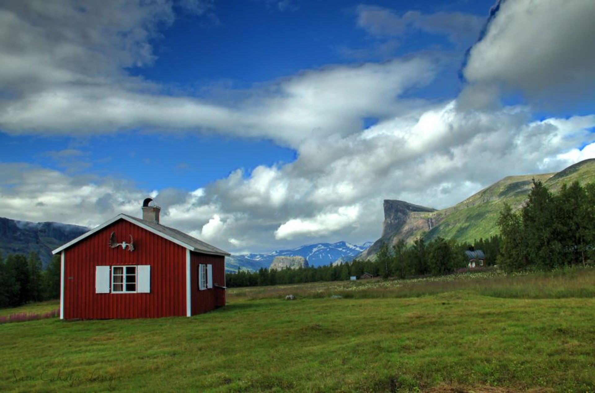 A red cabin in a valley.