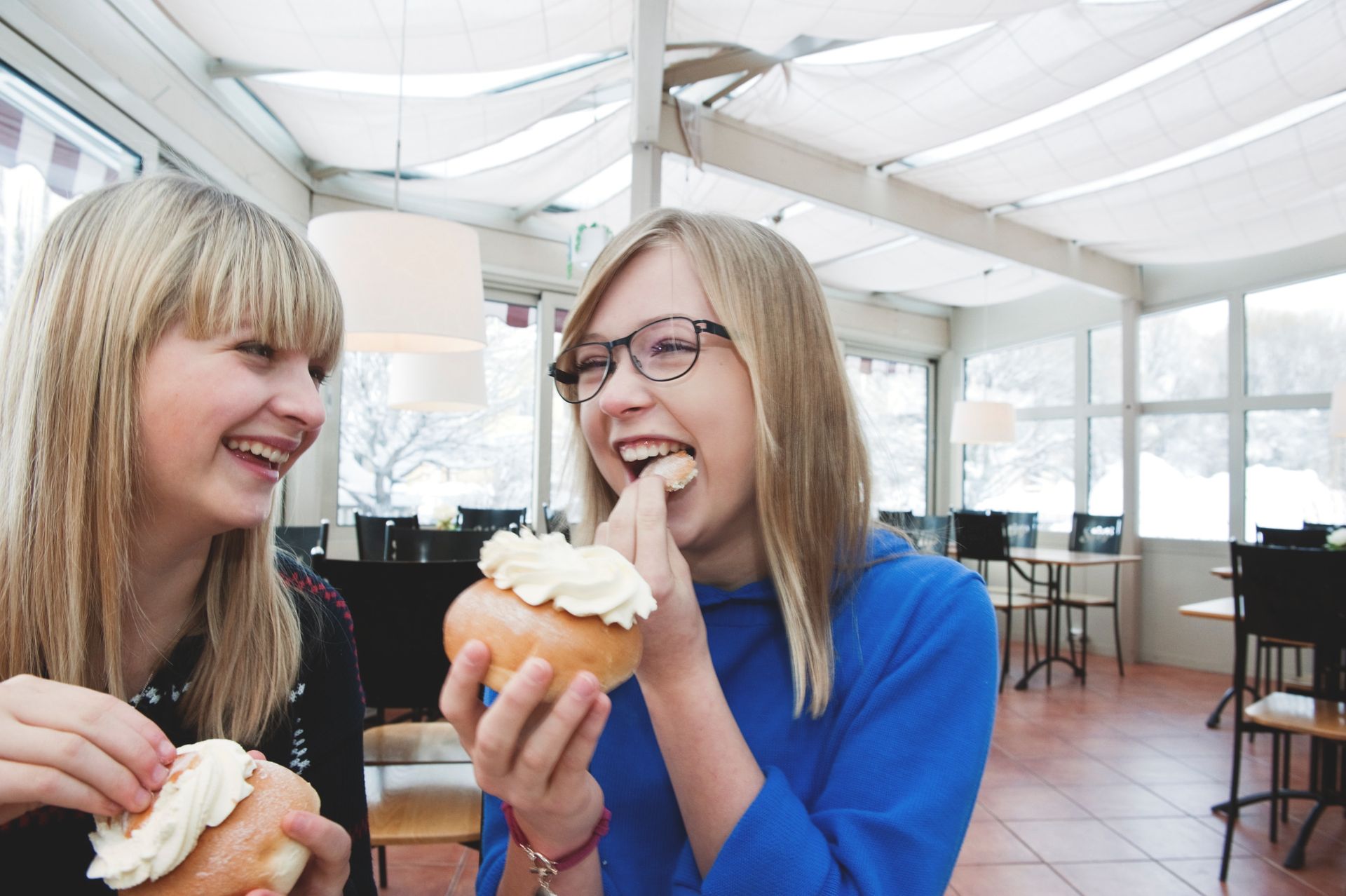 Two people eating pastries.