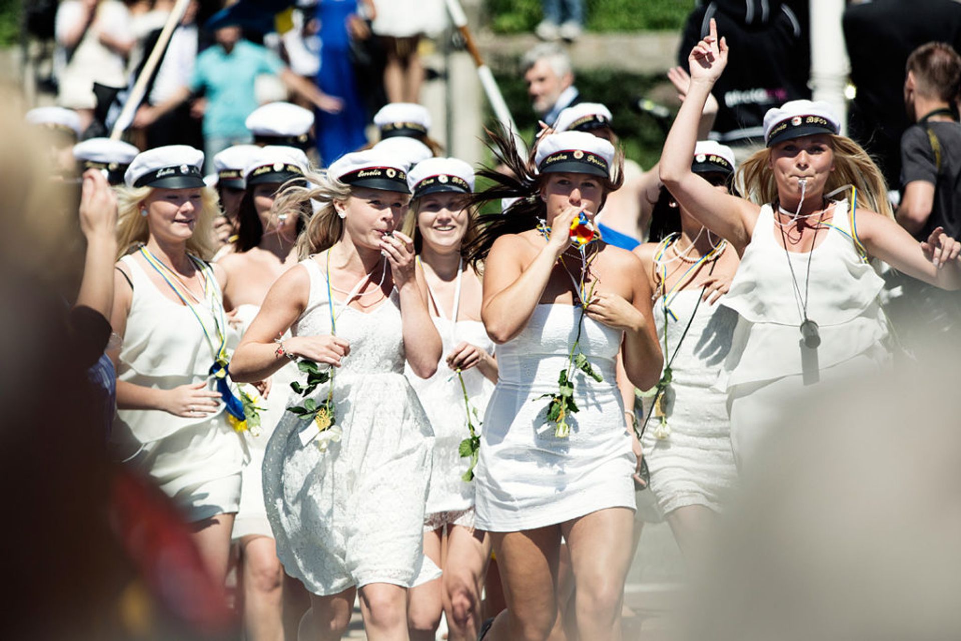 A group of high school girls in white dresses.