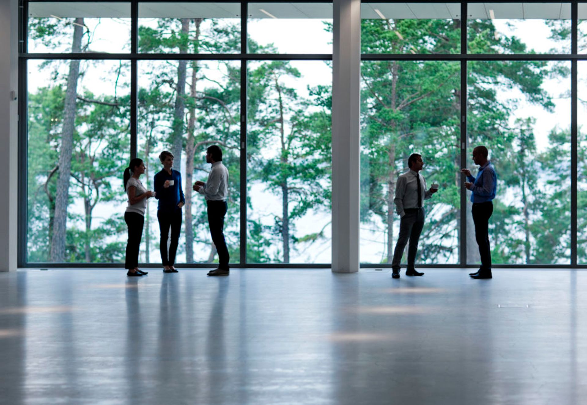 People standing and drinking coffee together.