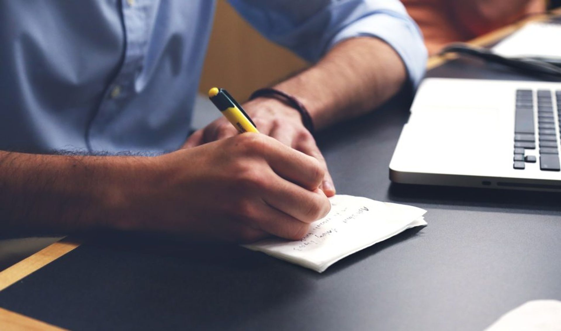 Close-up of person writing a note by hand.