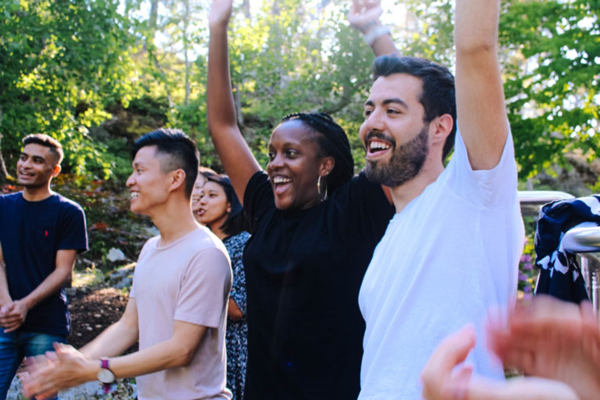 Digital ambassadors stand and cheer at people running a egg and spoon race.