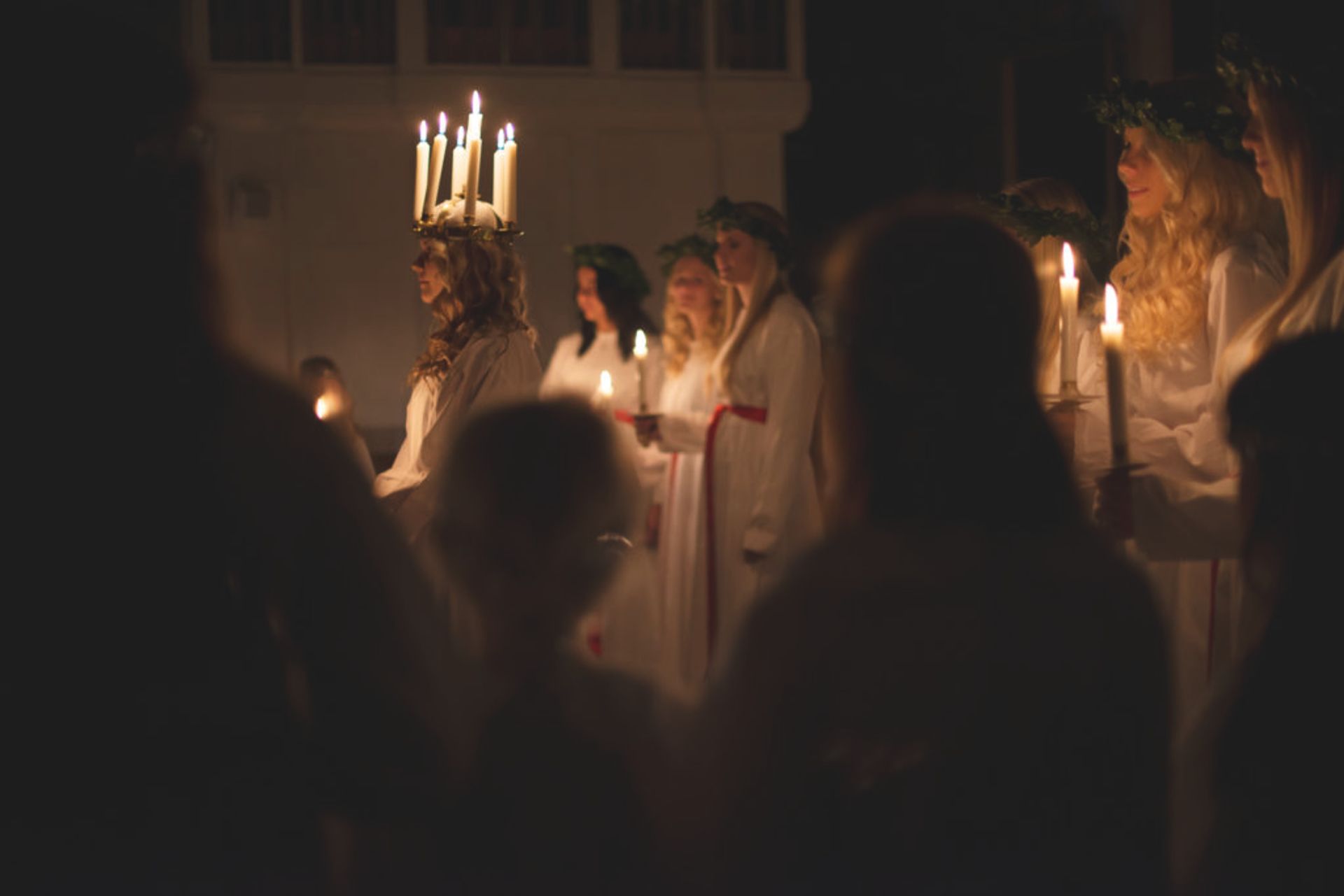 People holding candles as a part of a Lucia celebration.