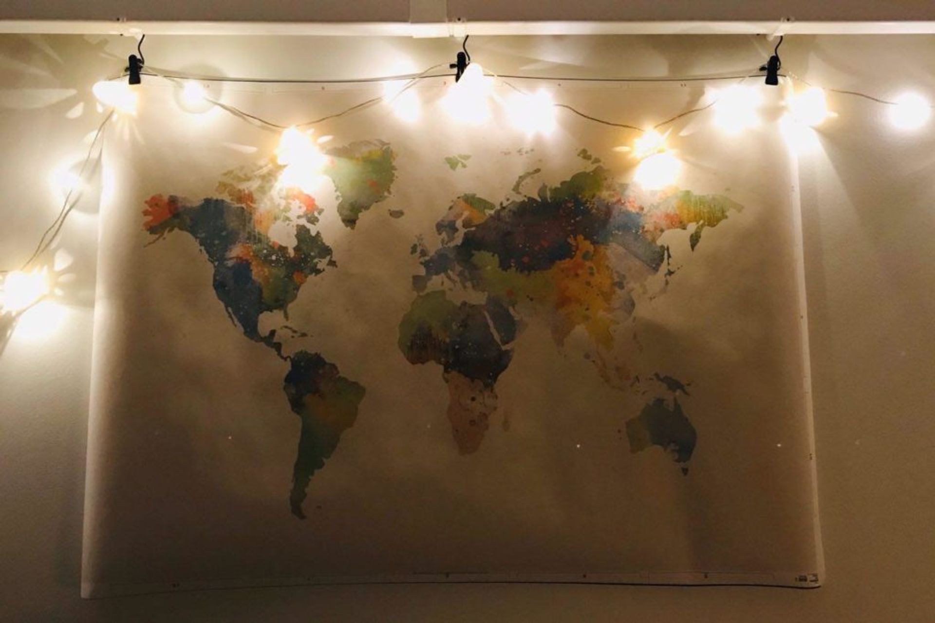 A world map hanging on a wall.