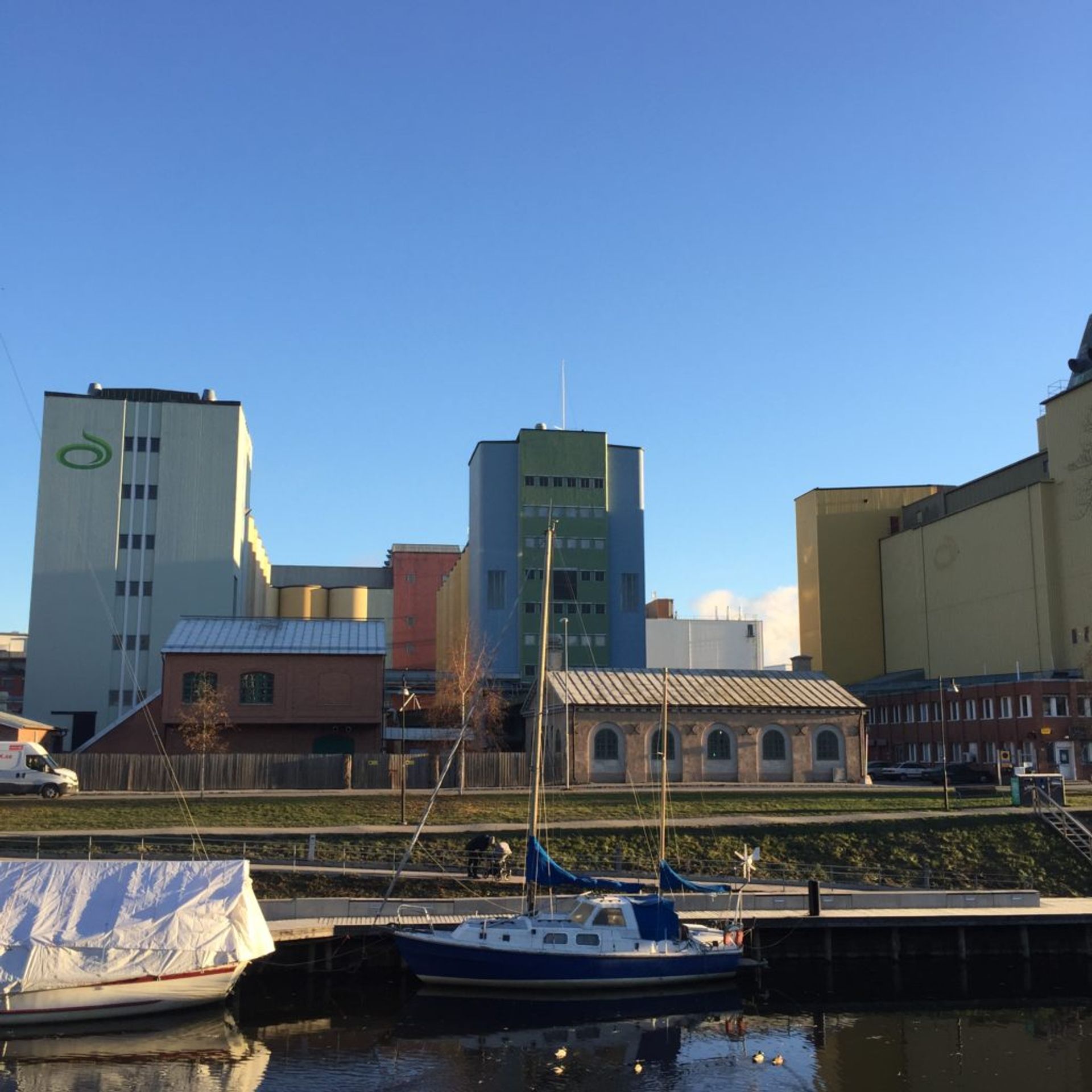 Colourful industrial buildings alongside river in Uppsala.