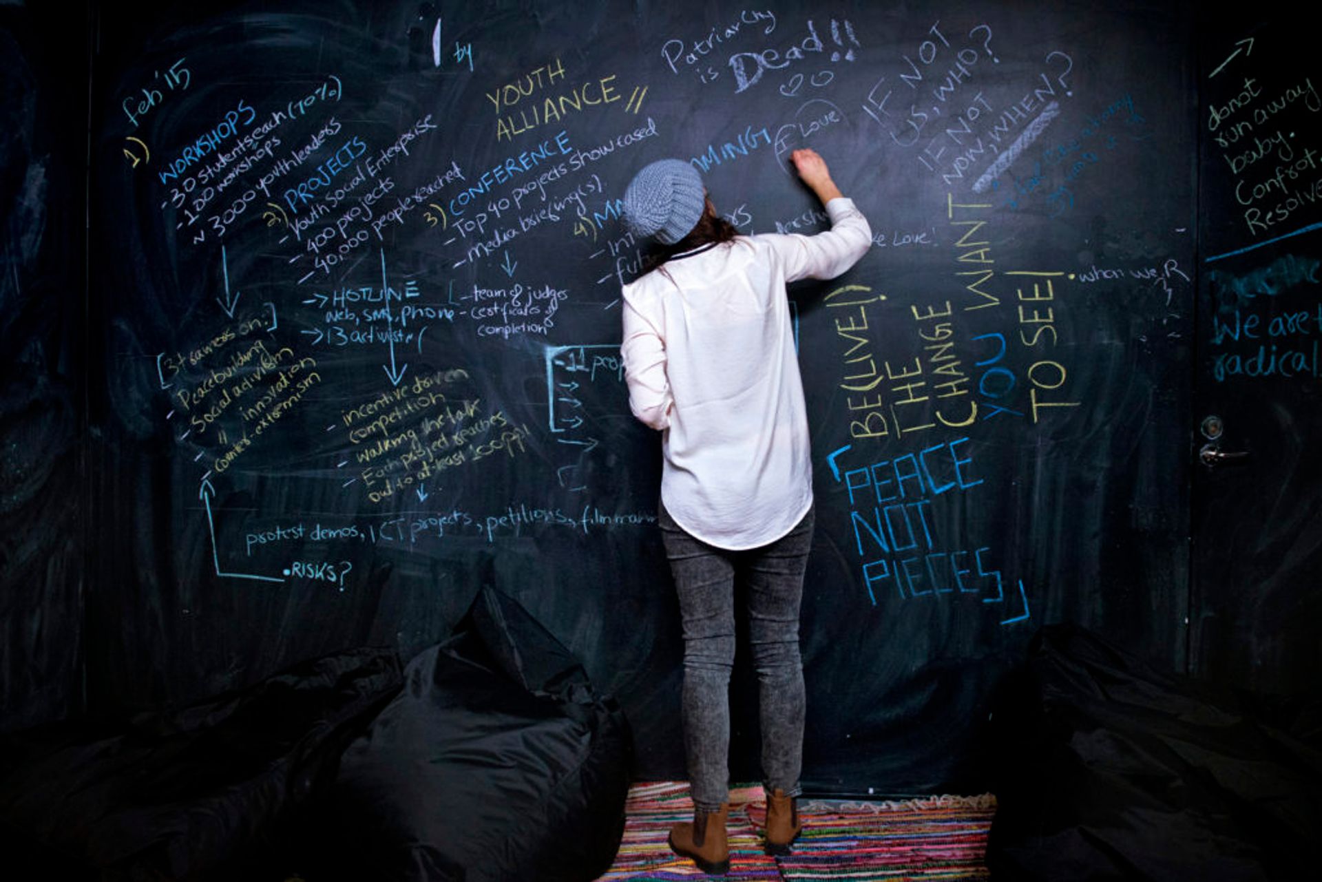 A social sciences student writes in chalk on a blackboard.