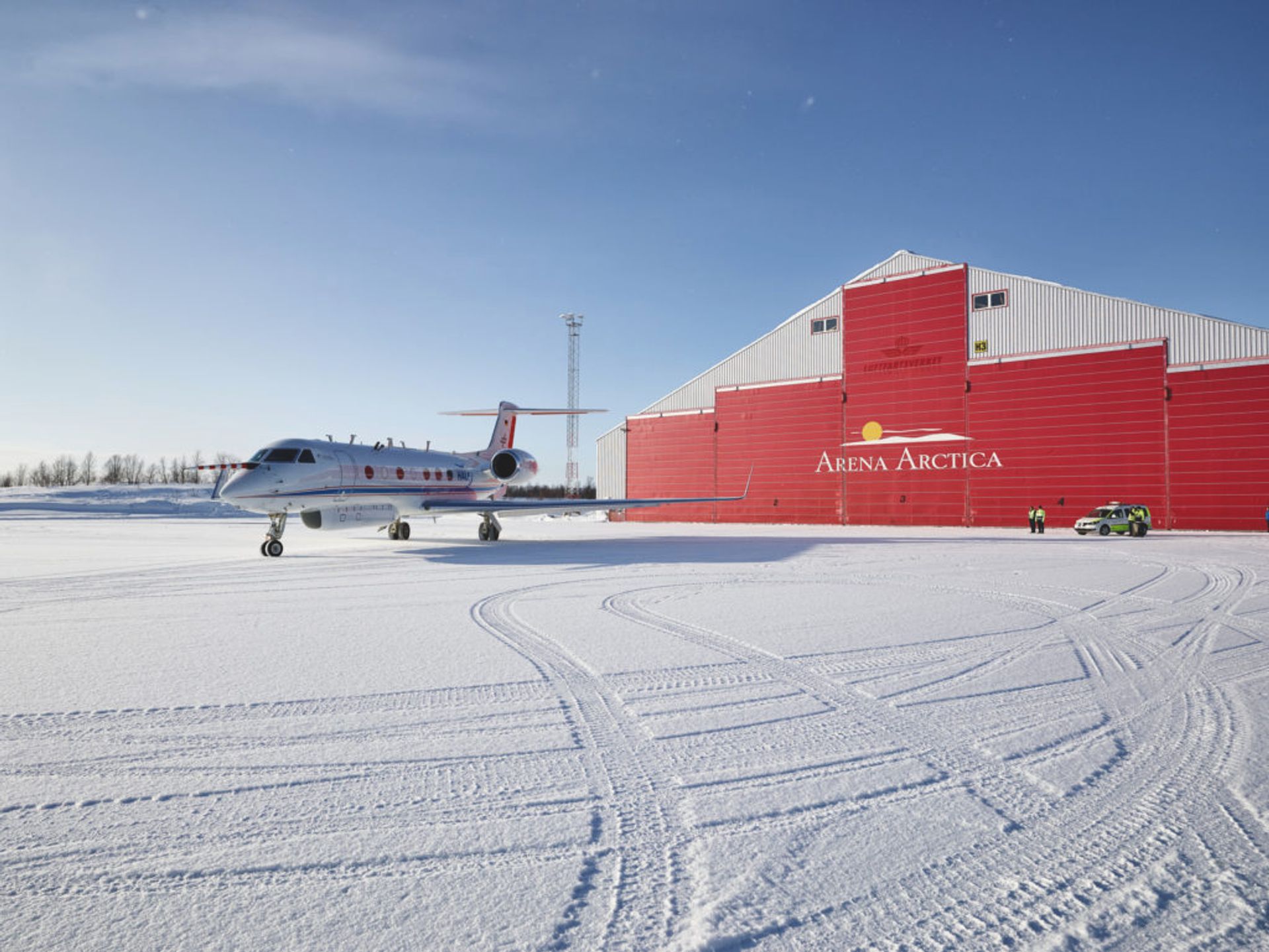 An aeorplane stands still at a snowy airport.