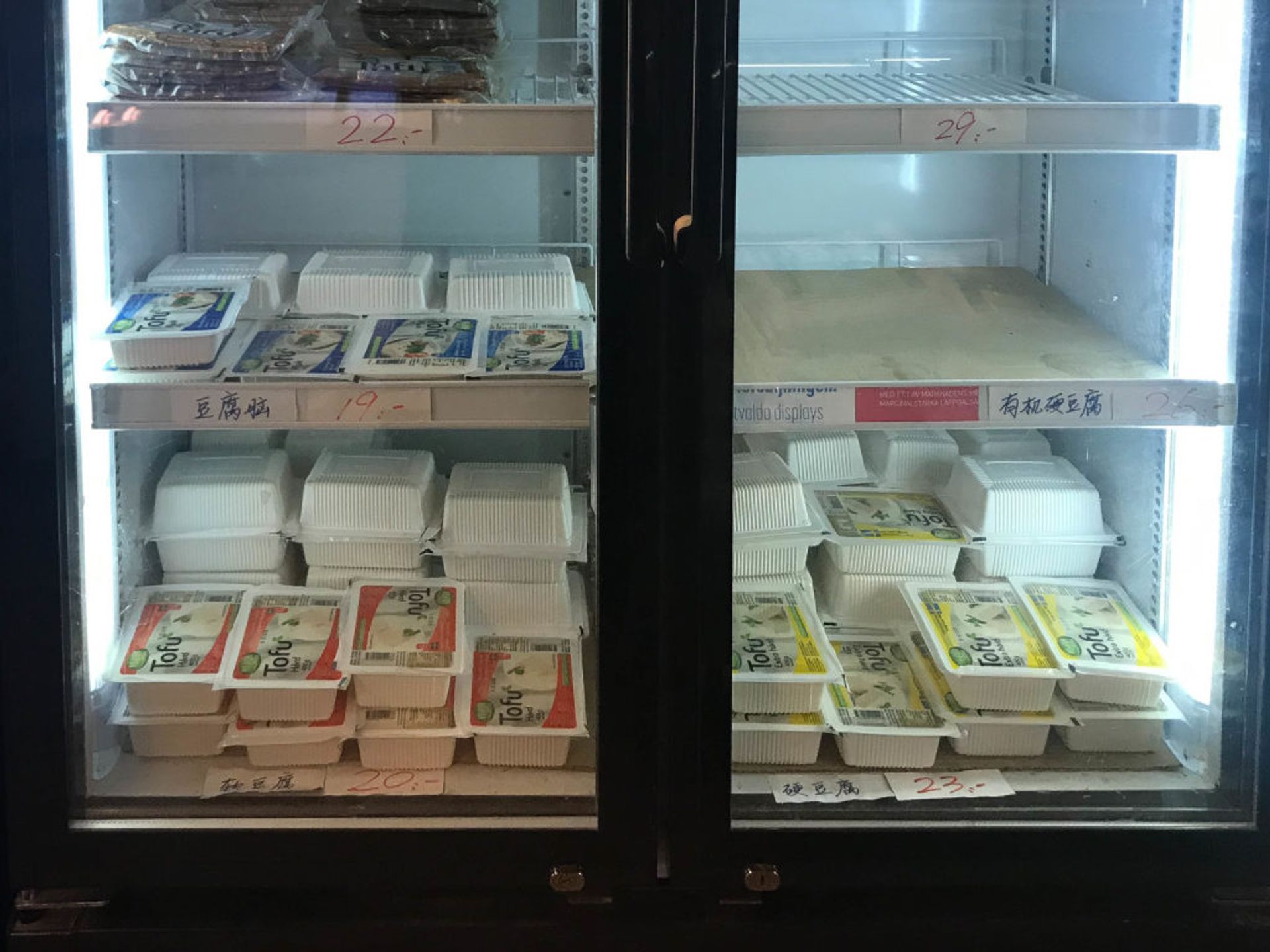 Shelves of tofu in a fridge.