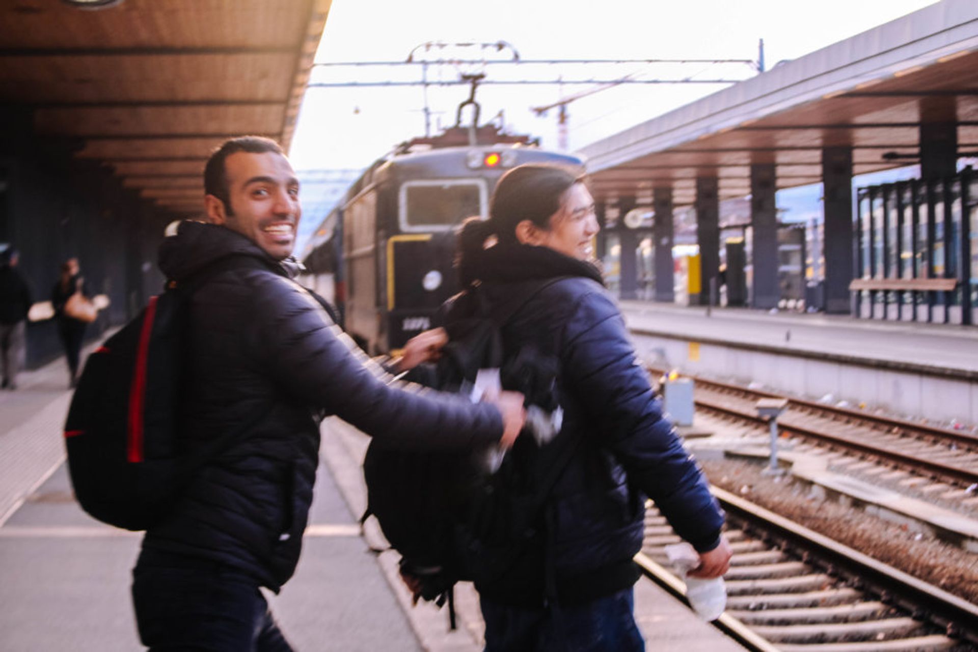 Two people standing at the train station.