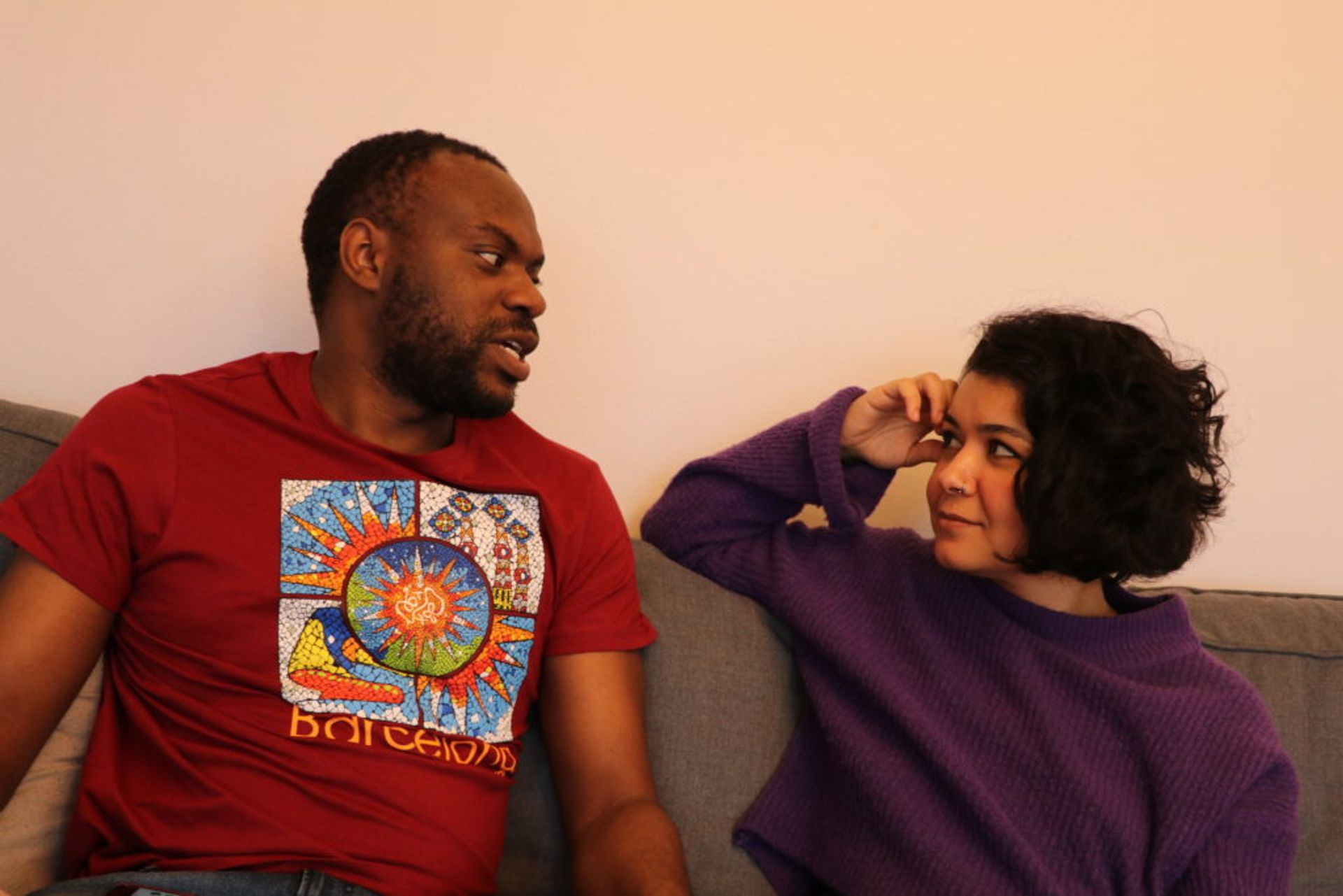 A woman and a man talking about scholarships on a couch.