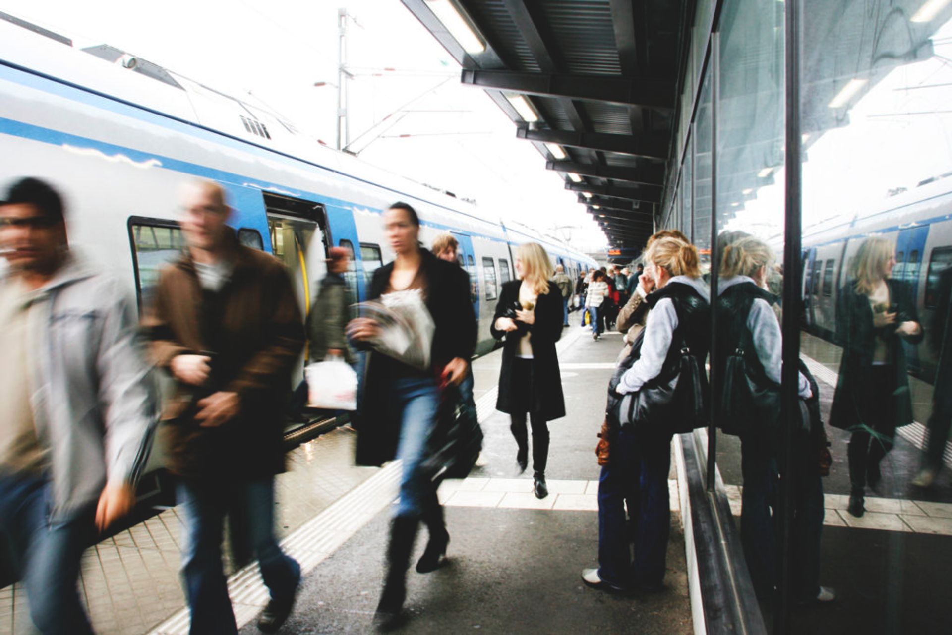 People walking along a train platform