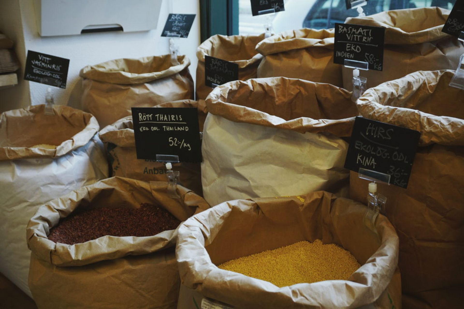 Brown big bags with rolled down edges with  different grain such as "Red that rice" and "Basmati white rice".