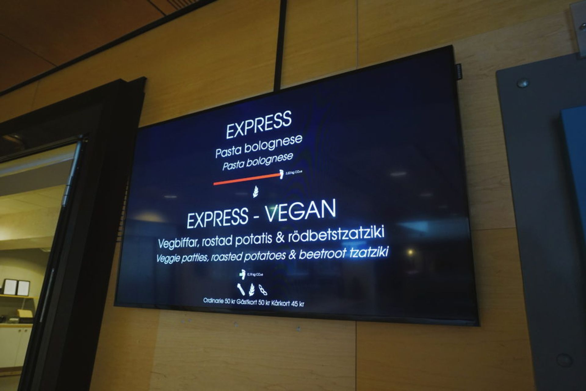 A TV showing what dishes that can be expressed delivered. It is a Pasta Bolognese or a vegan option of veggie biffs.
