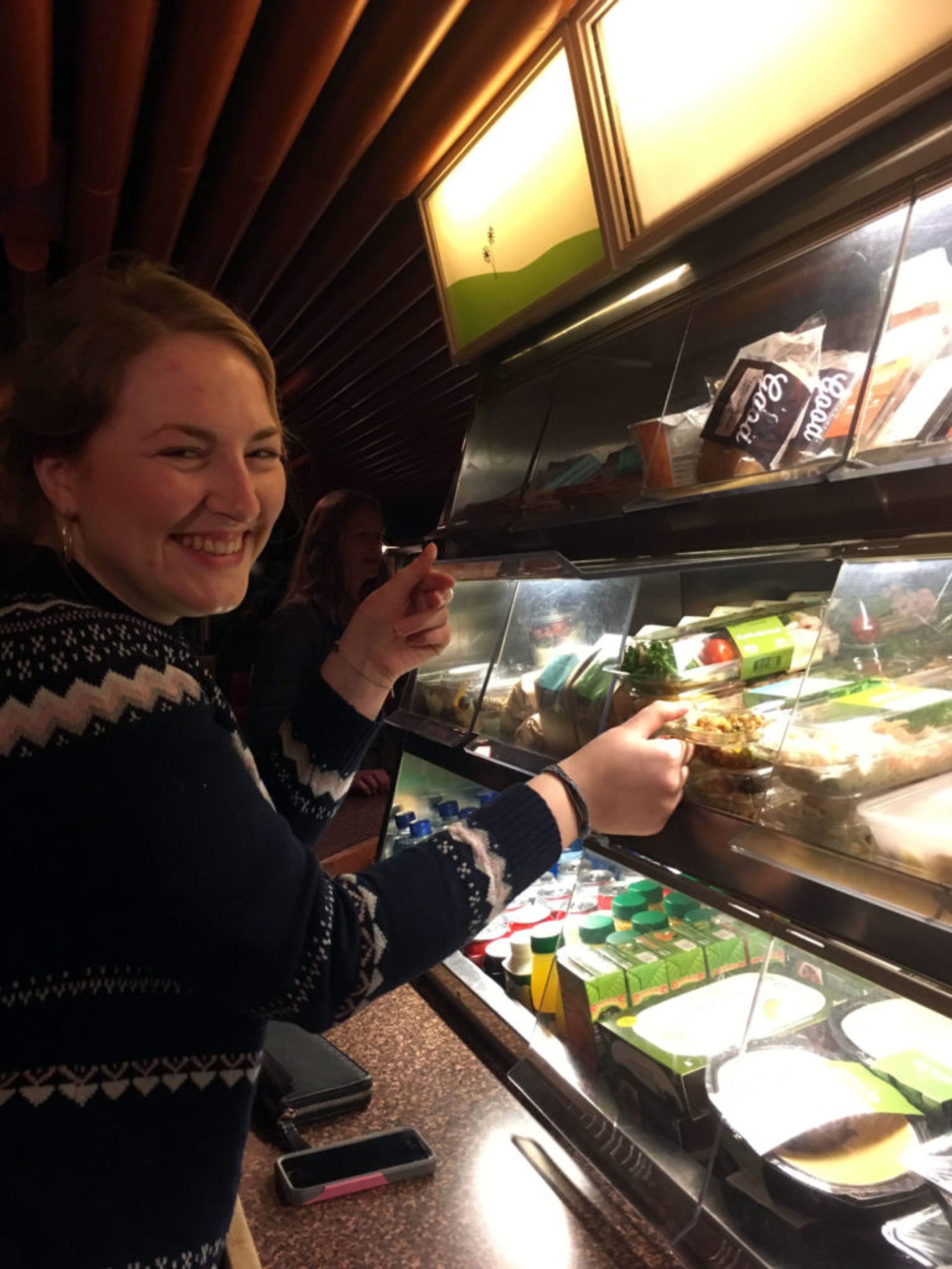 A woman selecting a sandwich from the bistro carriage. 