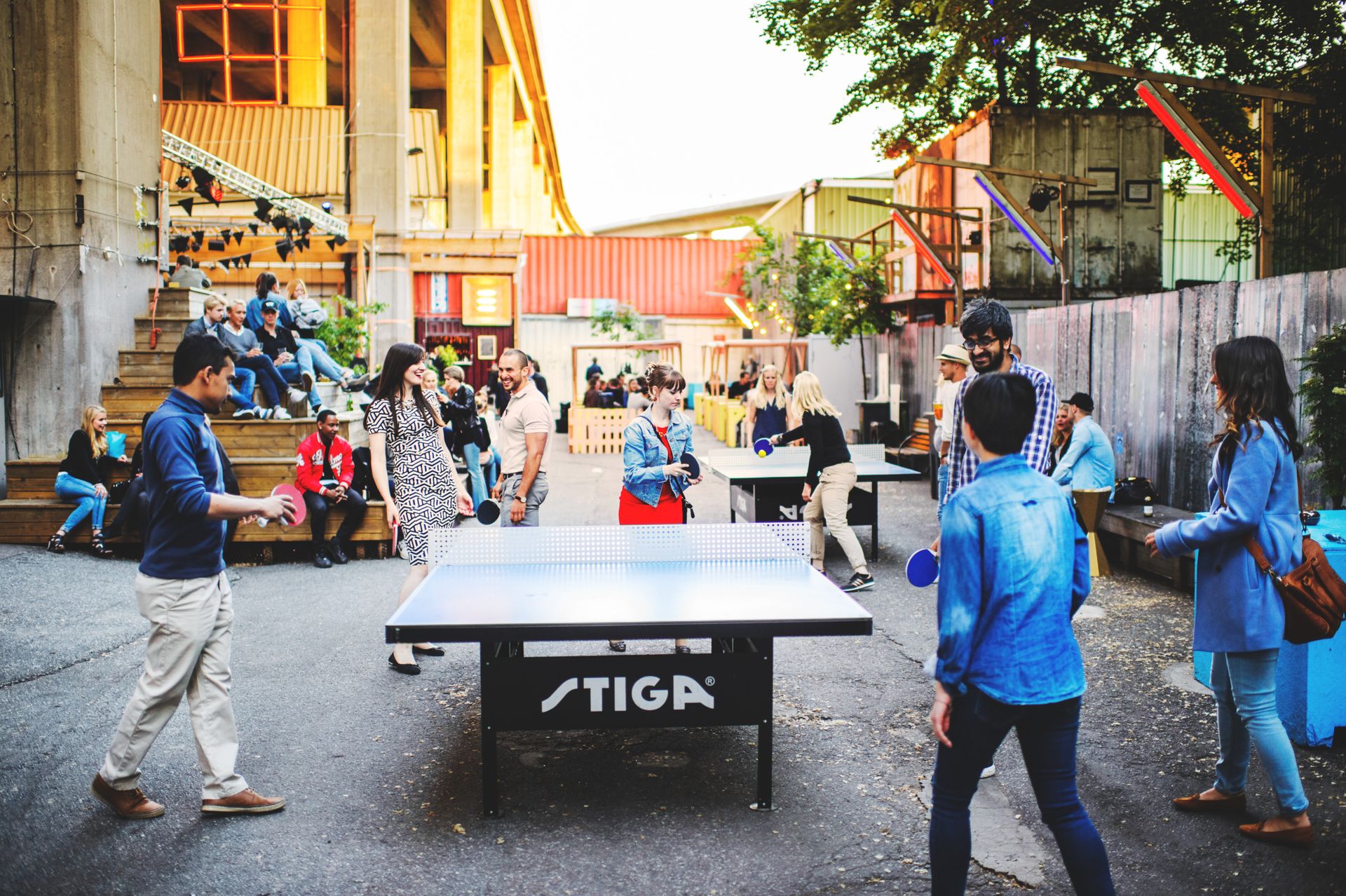 People playing table tennis outside.