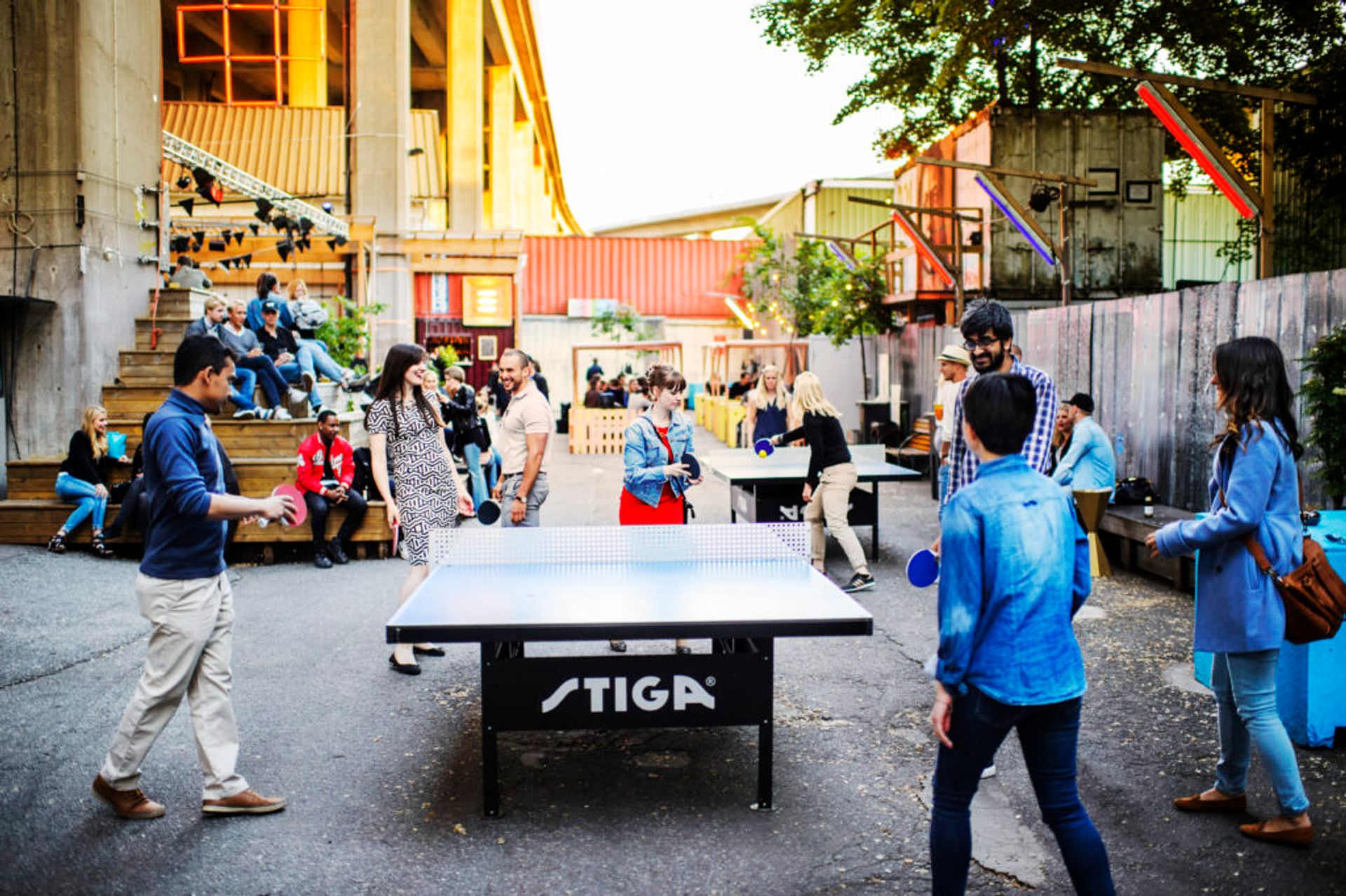 Students playing table tennis outside.