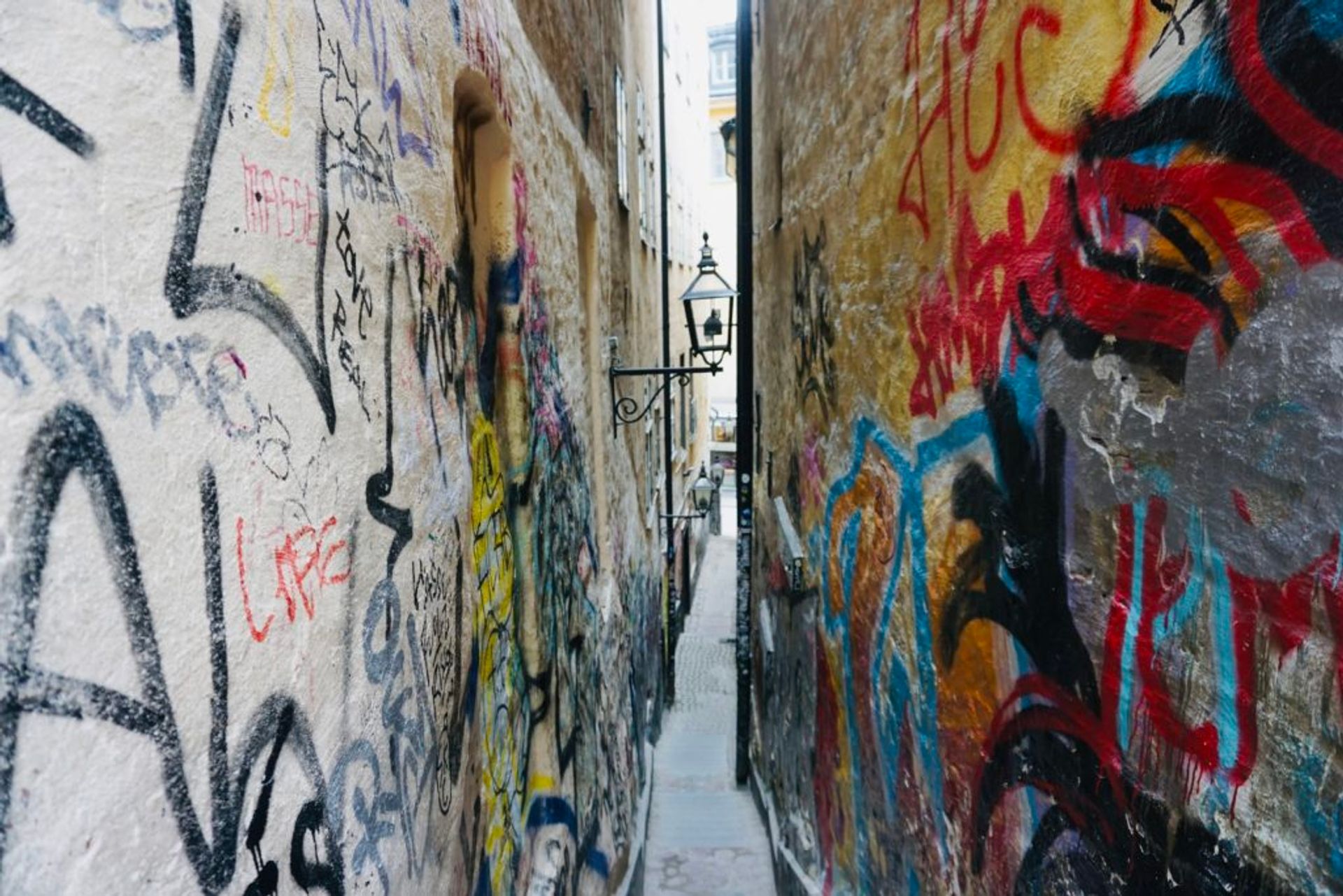 Graffiti covering walls in a narrow alley.