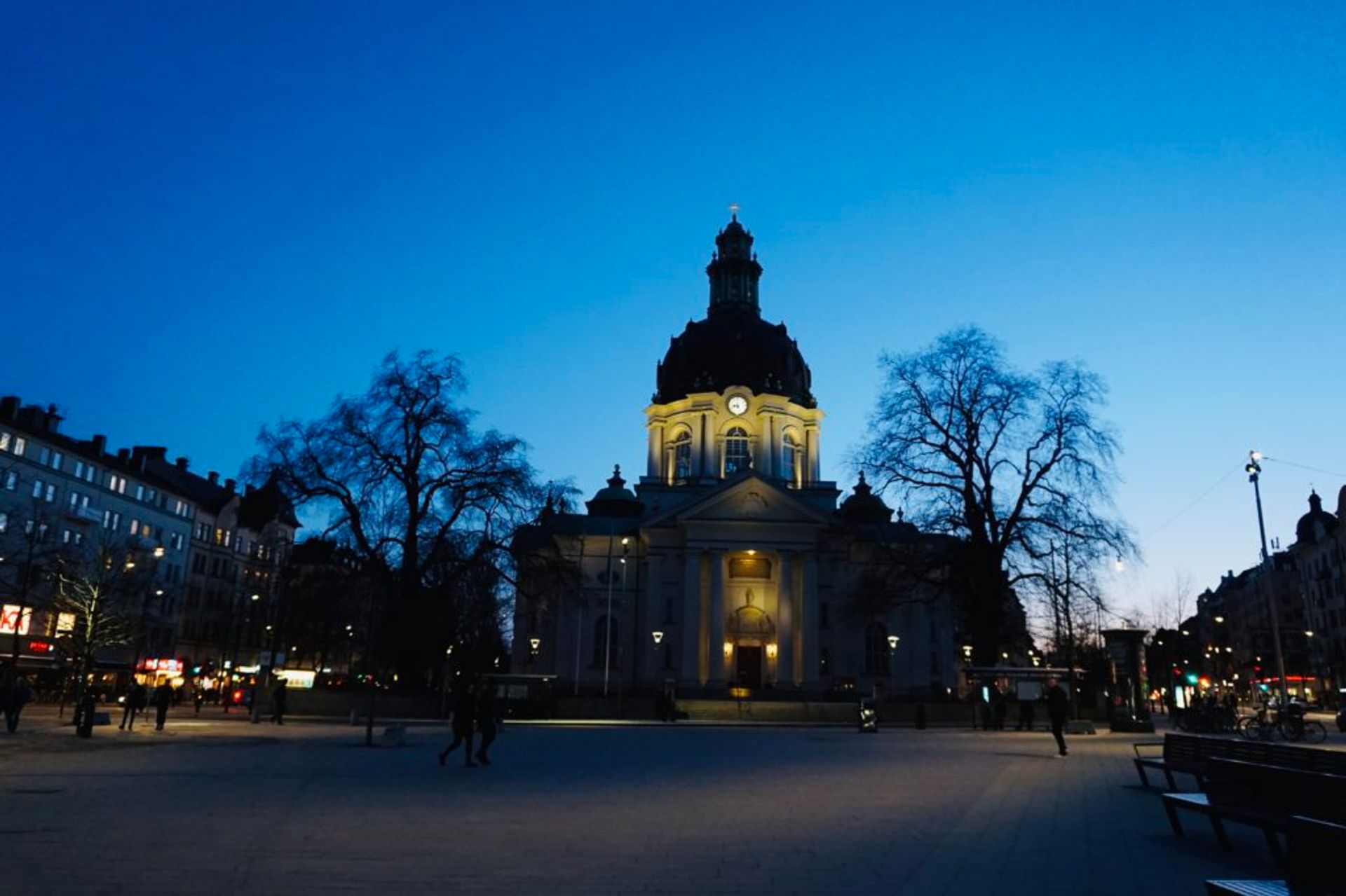 A church lit up by lights in a square.