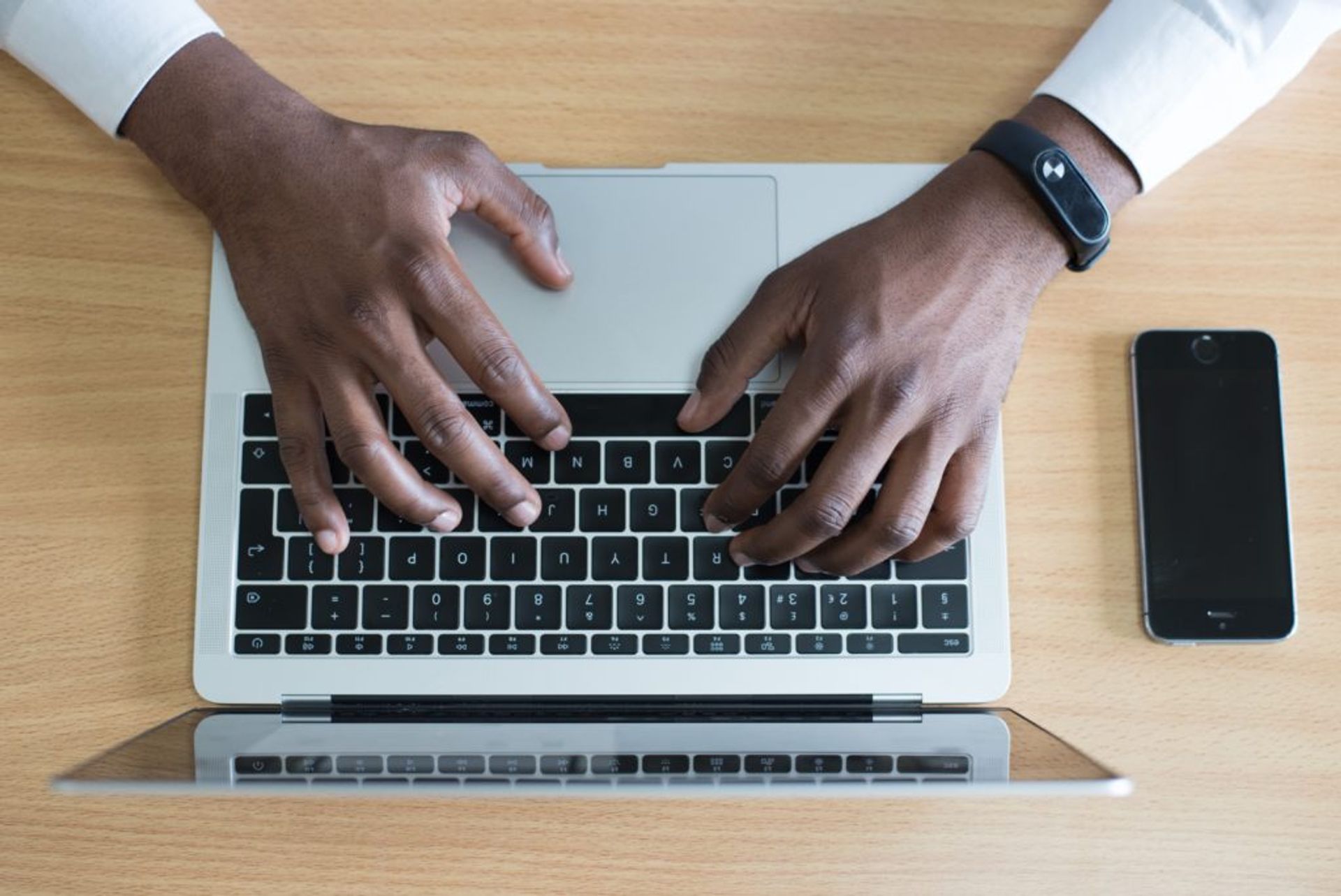 Close-up of a person typing on a laptop.