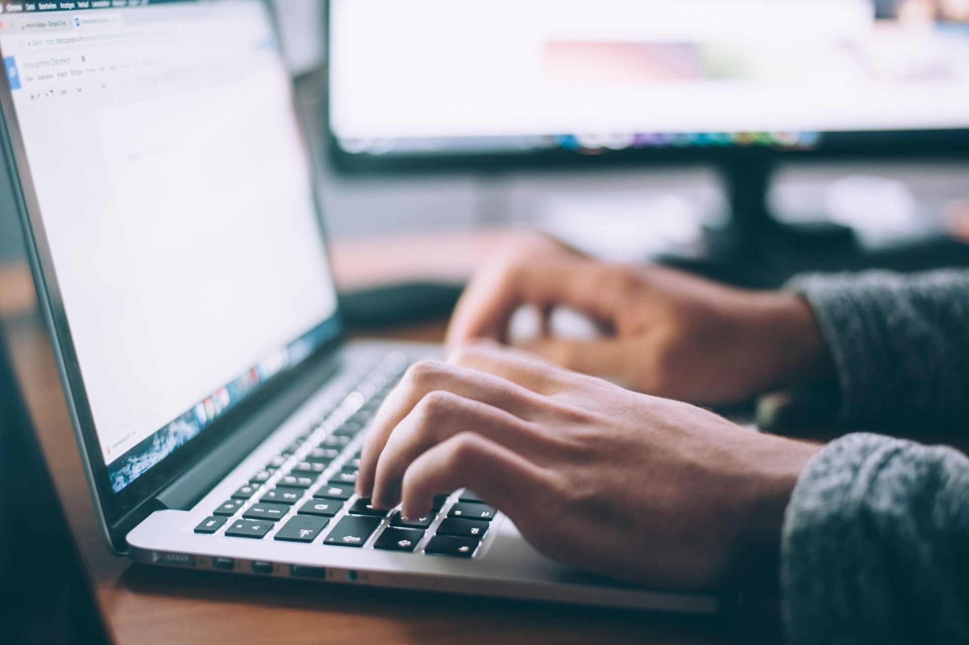 Close-up of person typing on a laptop.