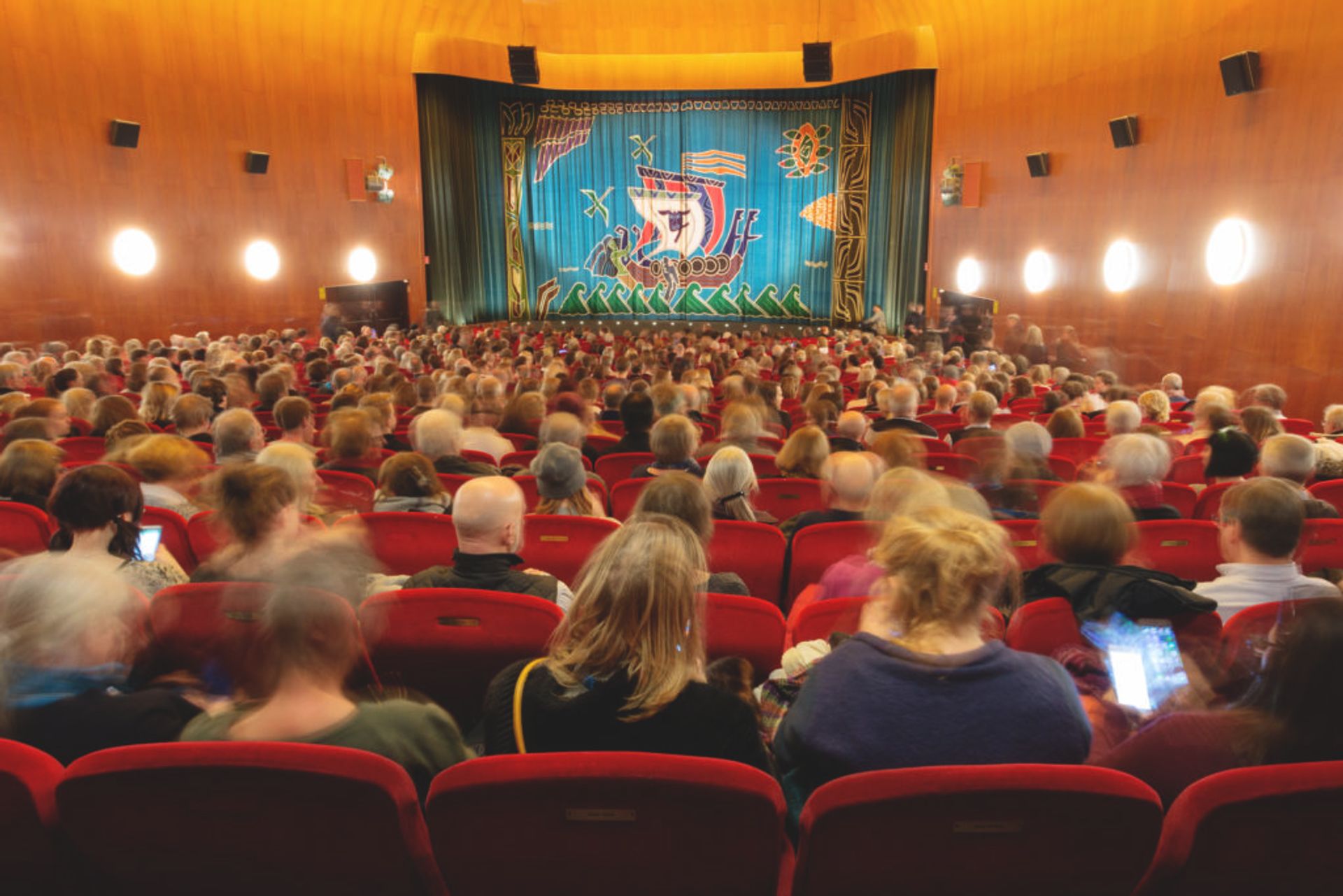 People in a cinema waiting for the movie to start.