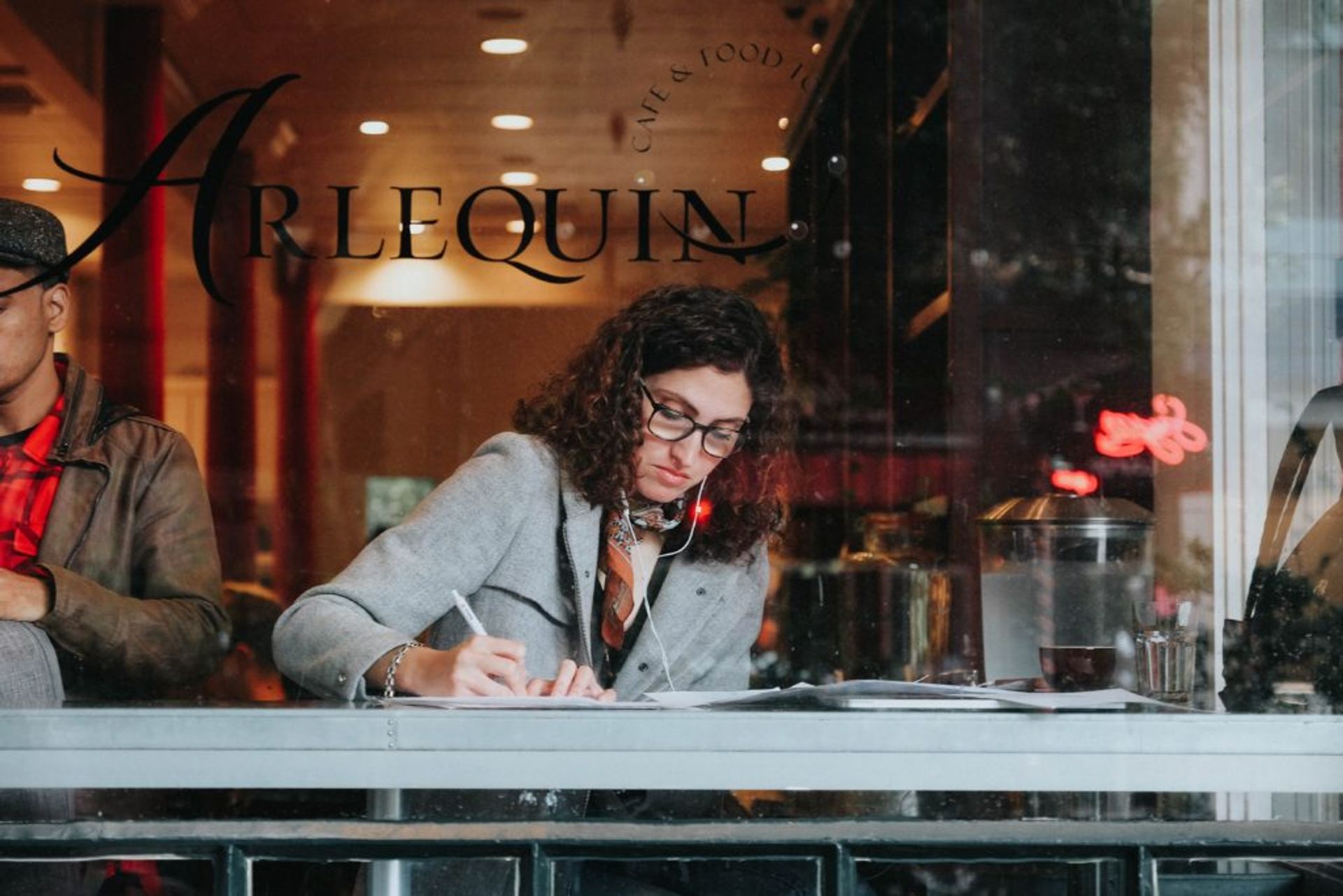 Woman sitting in a cafe writing.