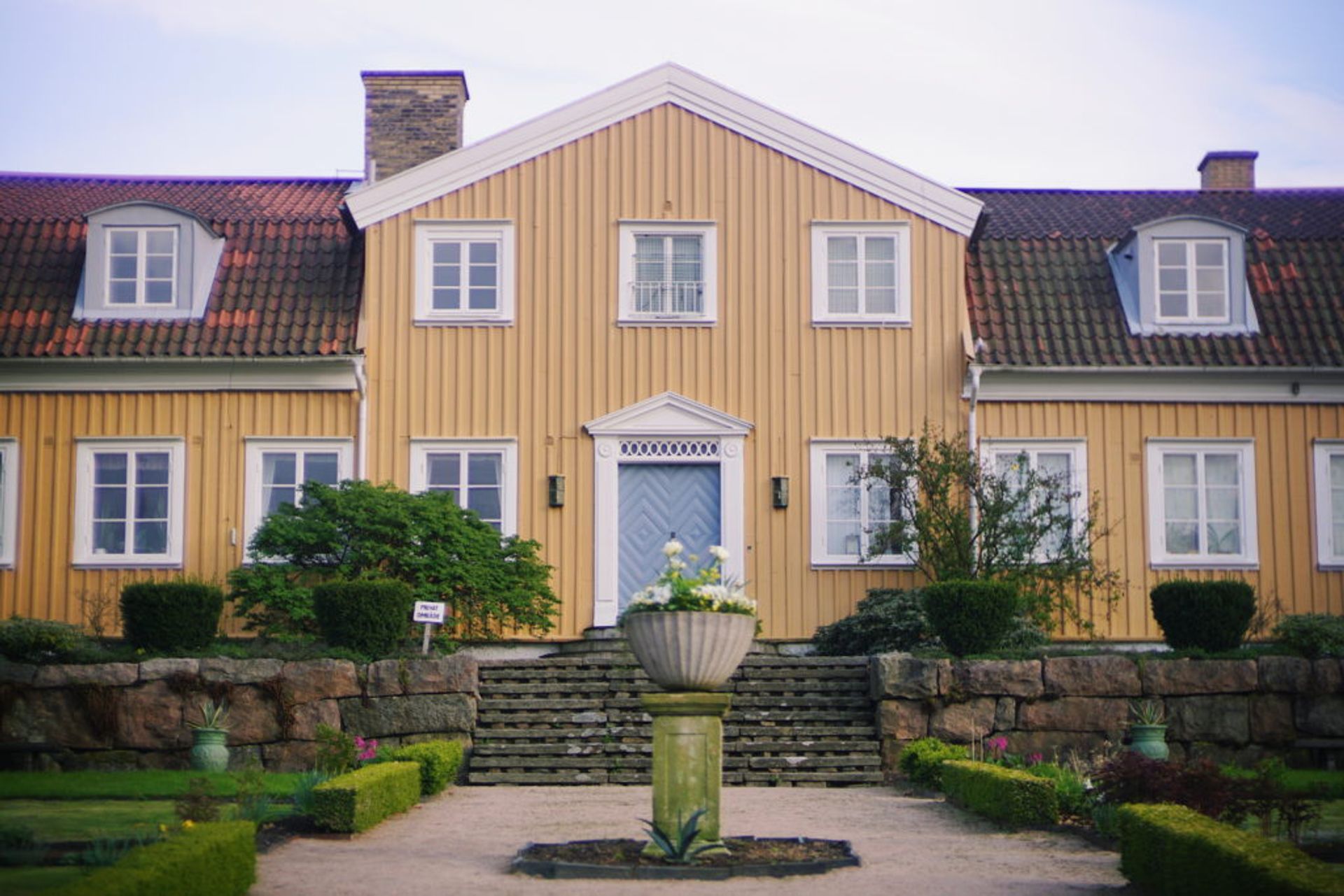 A yellow, wooden building in the botanical gardens.