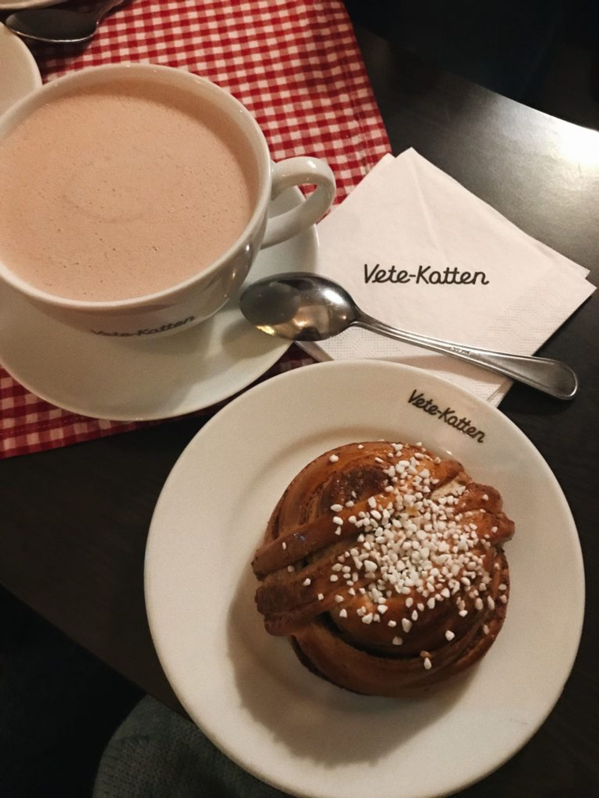 Close-up of a cinnamon bun and cup of coffee.