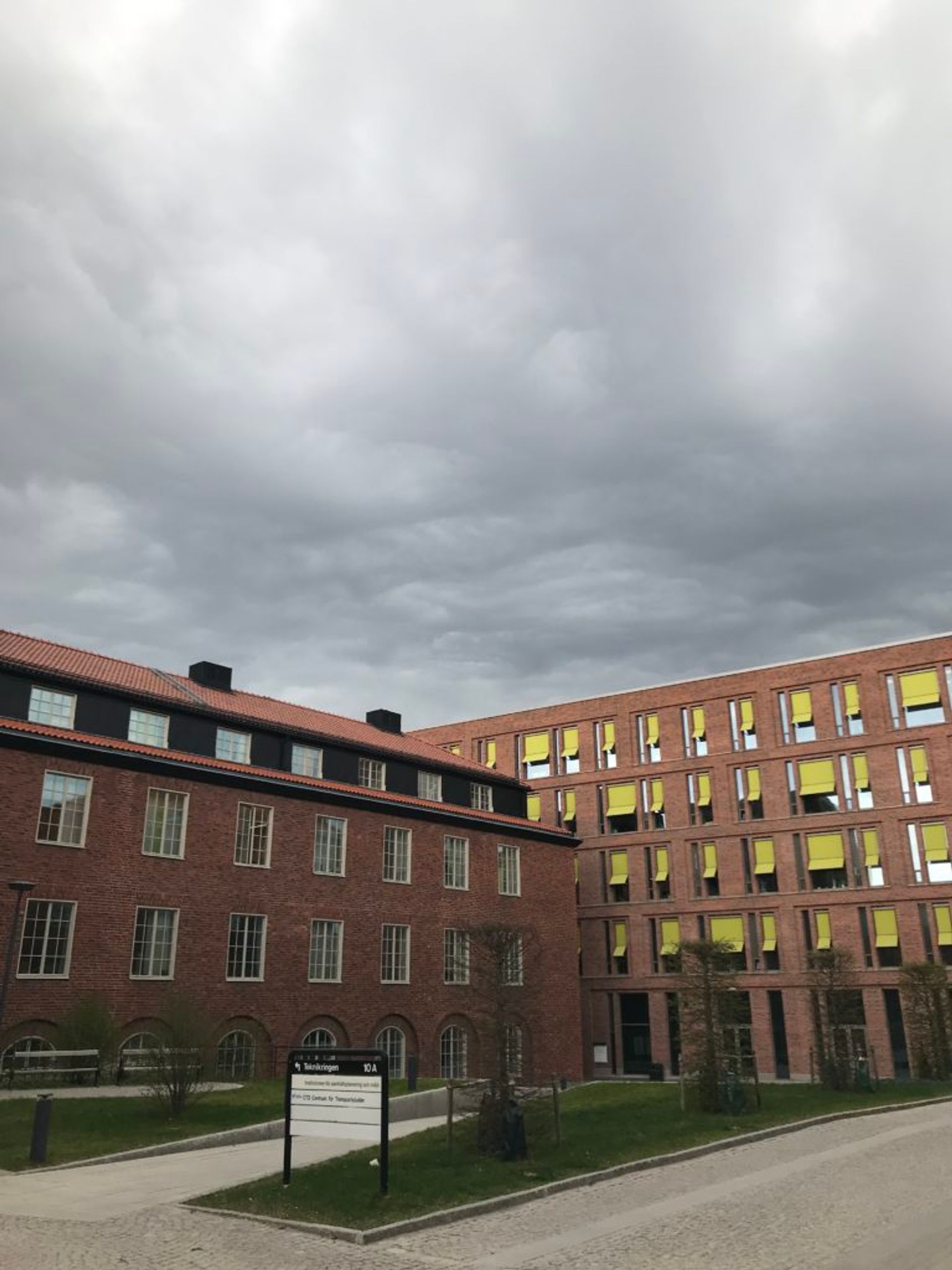 A red-brick university building on a cloudy day.