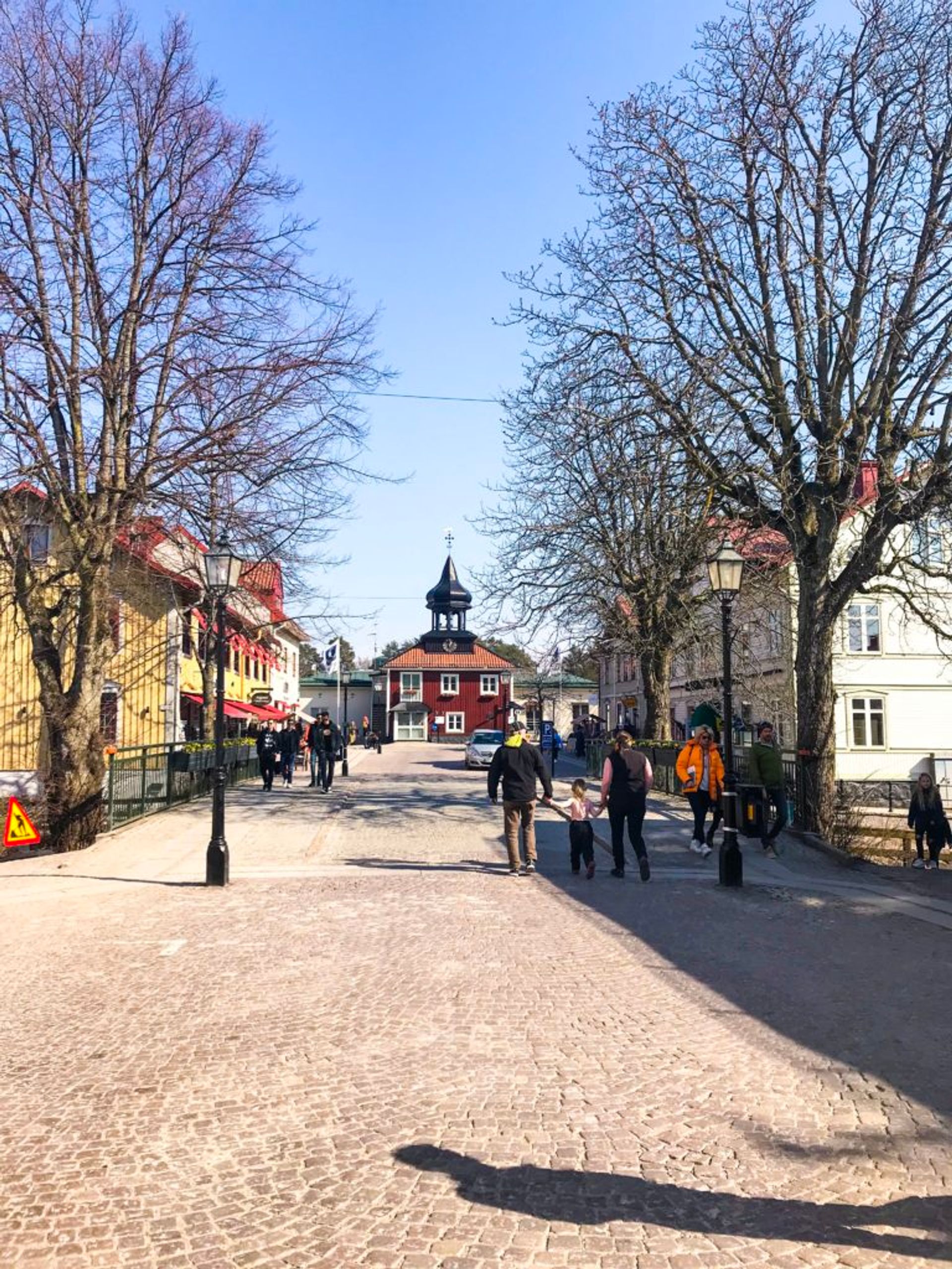 People walking along a cobbled street.