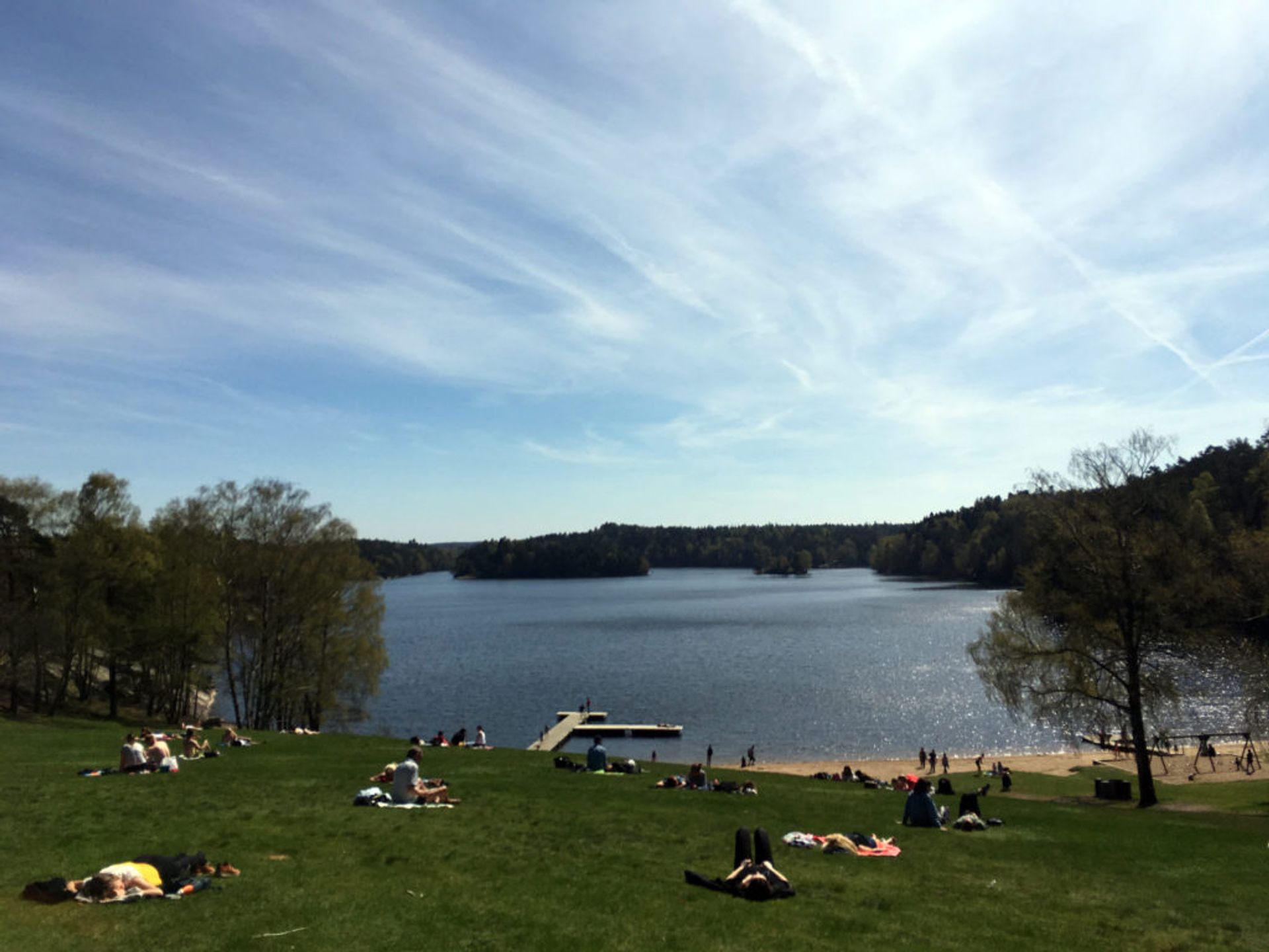 People sunbathing by the lake at Delsjön