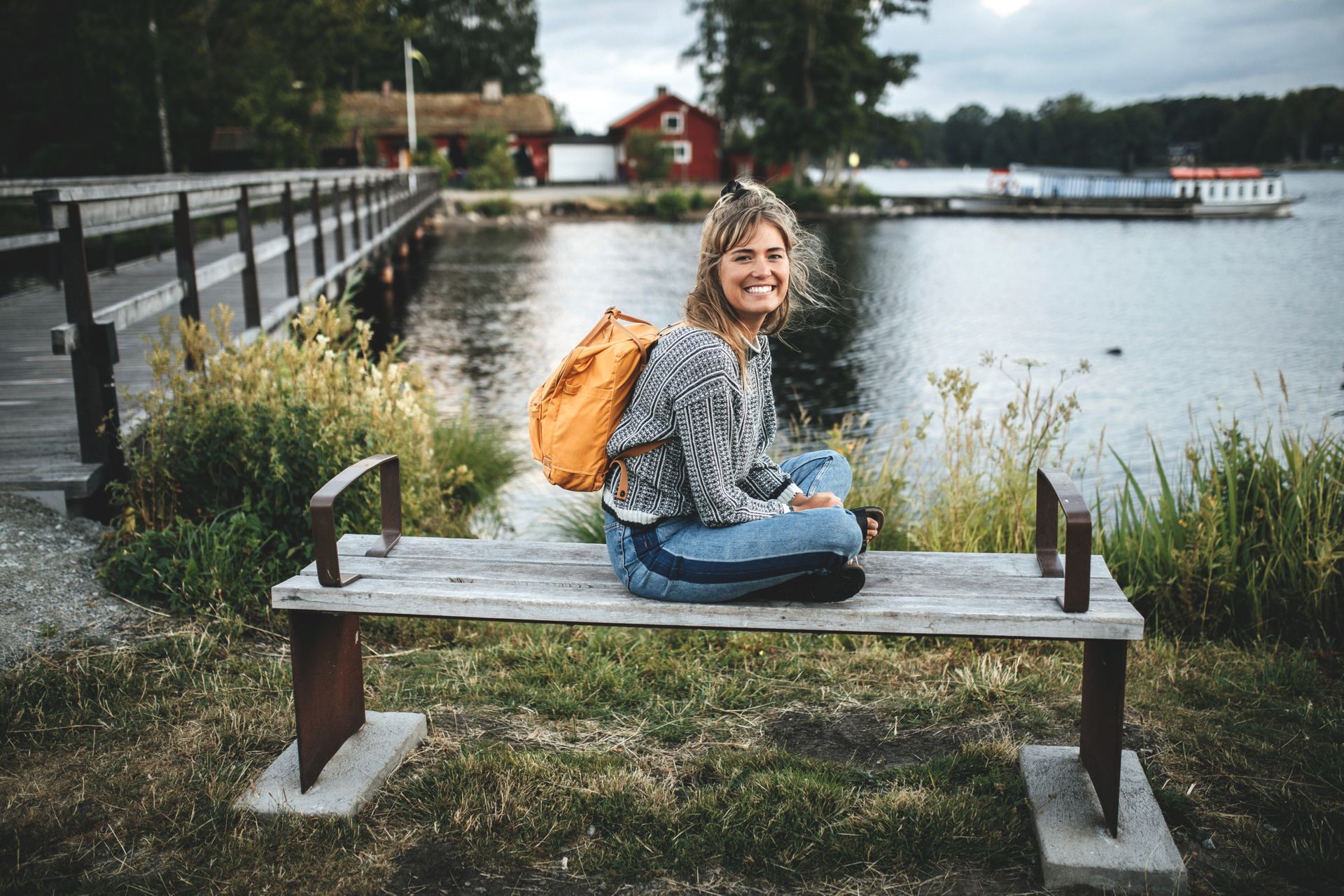 Woman sits on a bench in a park.