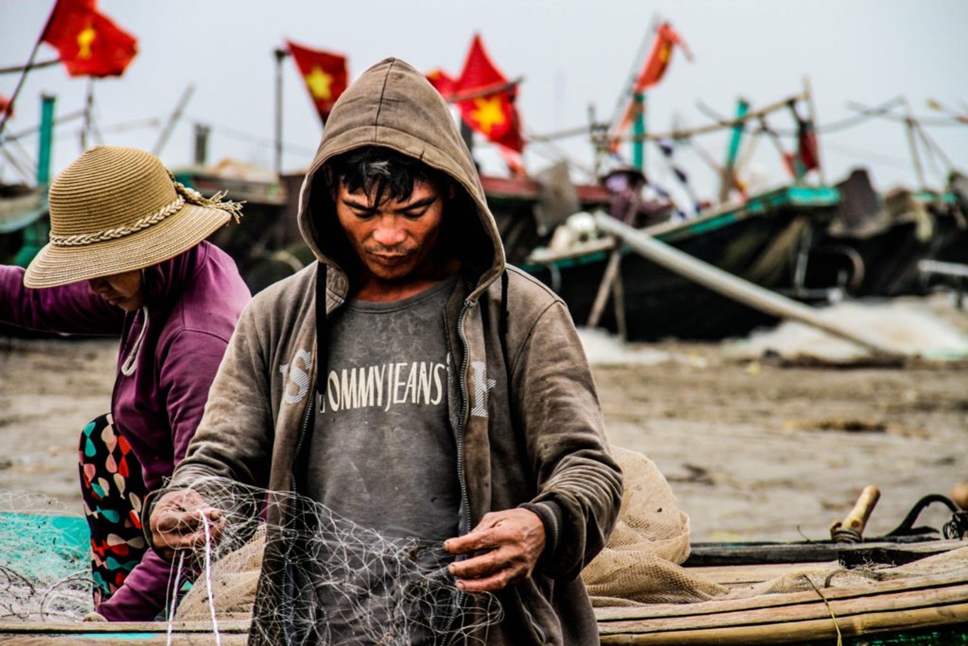 A fisherman looking at a fishing net.