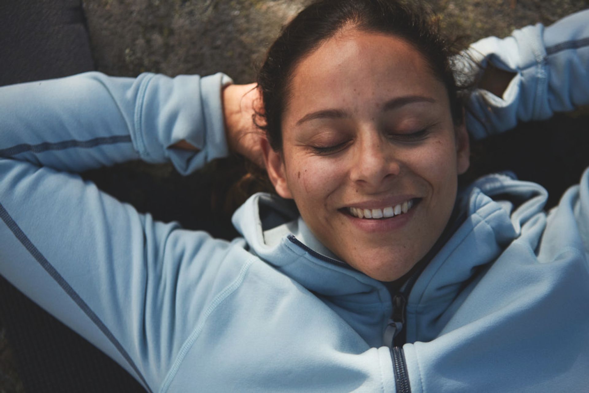 Woman lying on the ground with her eyes clothes.