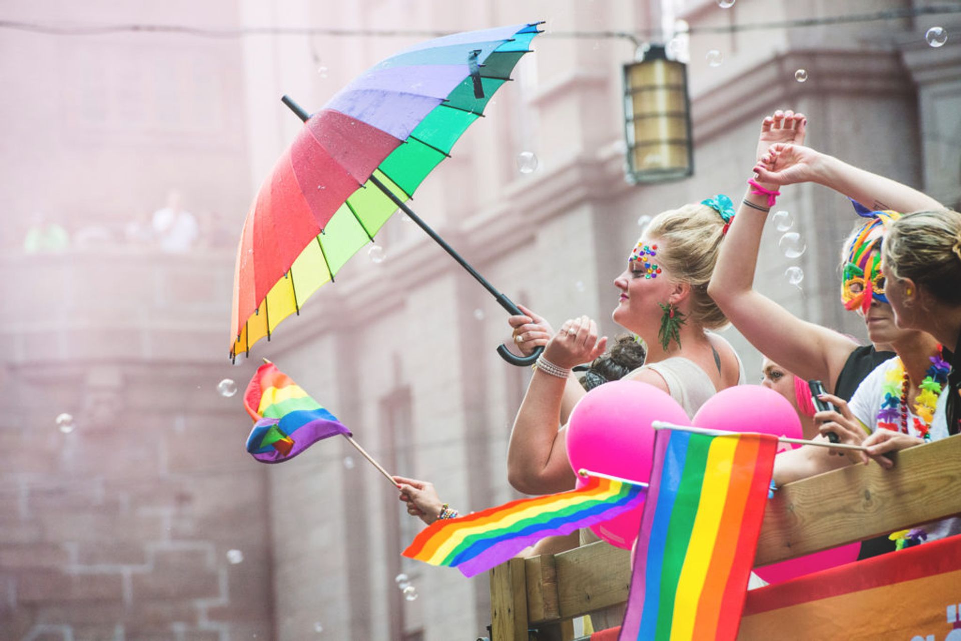 People waving rainbow flags on a float.