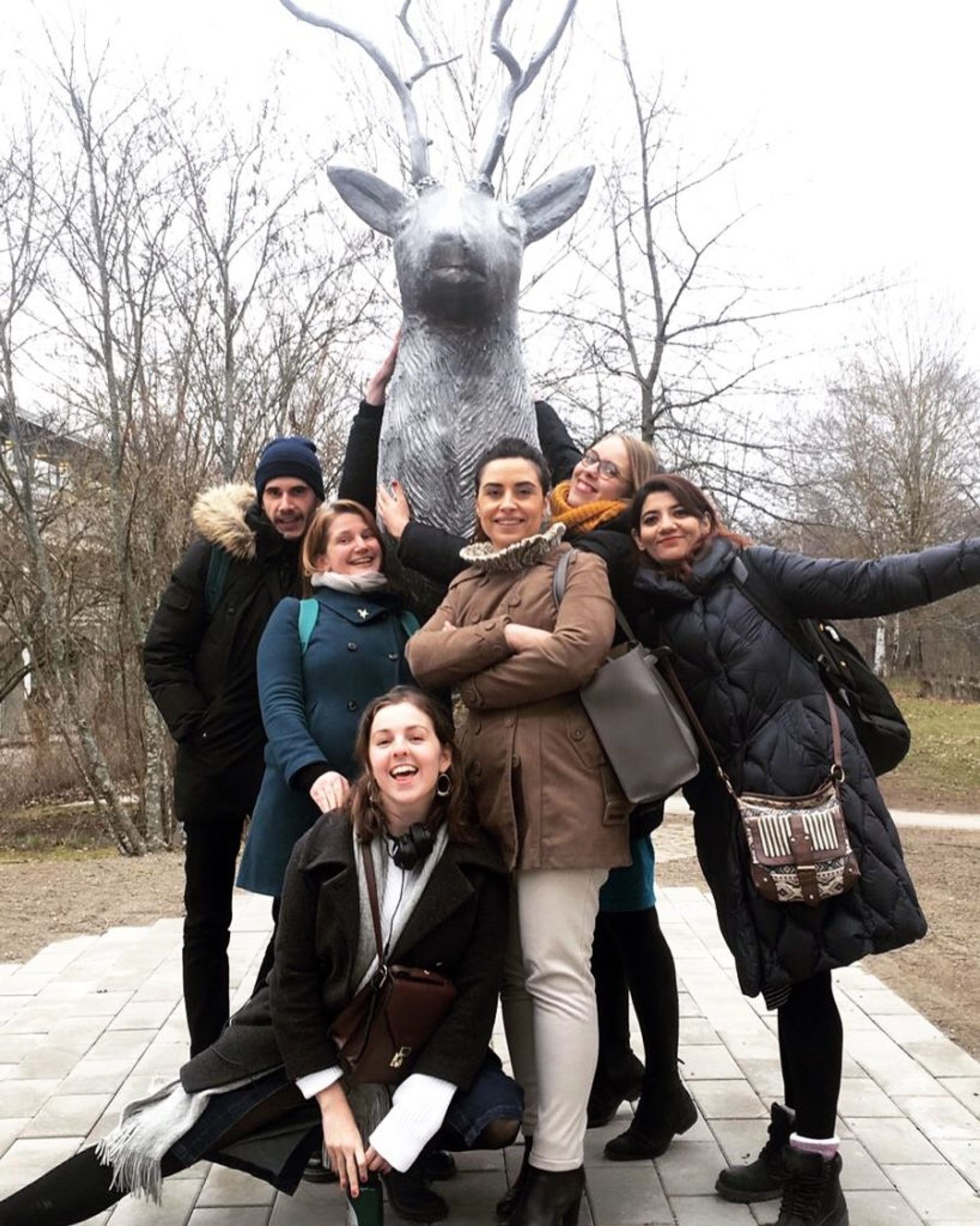 Students posing in front of a statue.