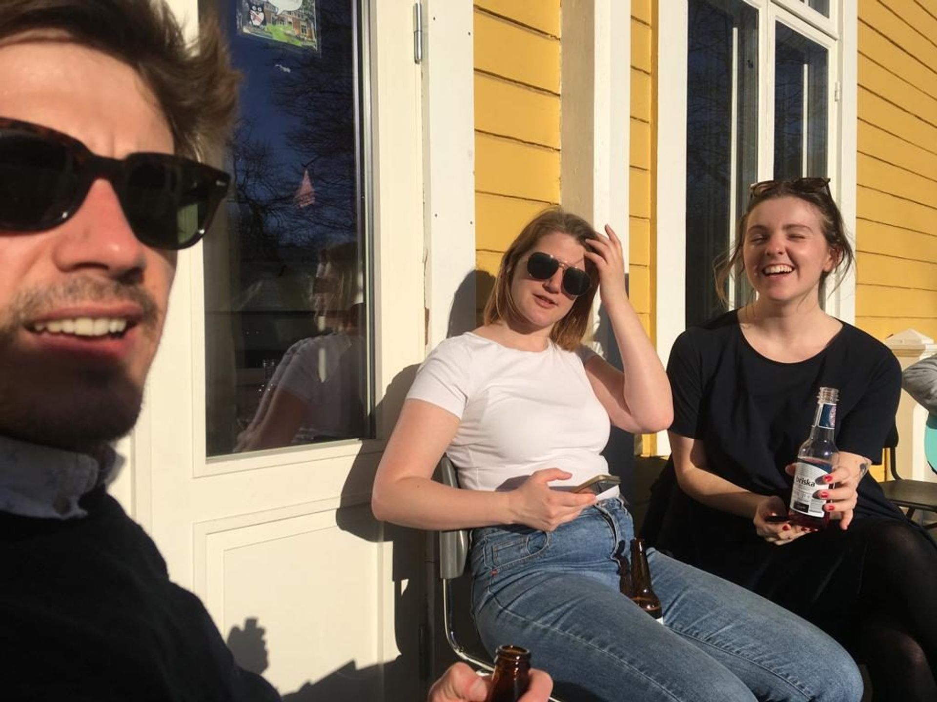 Students sitting outside a building in the sun.