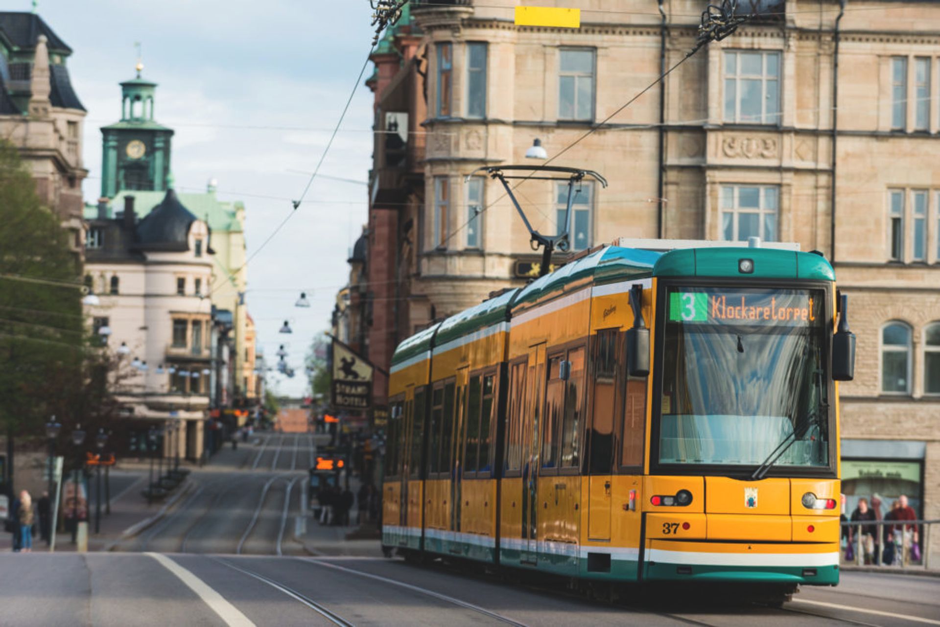 Yellow and green tram in a small Swedish city.