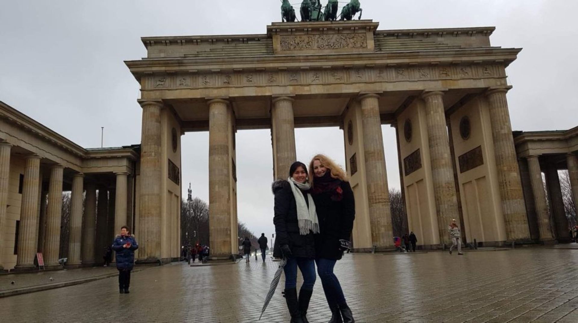 Two students posing for a photo in front of the Brandenburg Gate in Berlin.