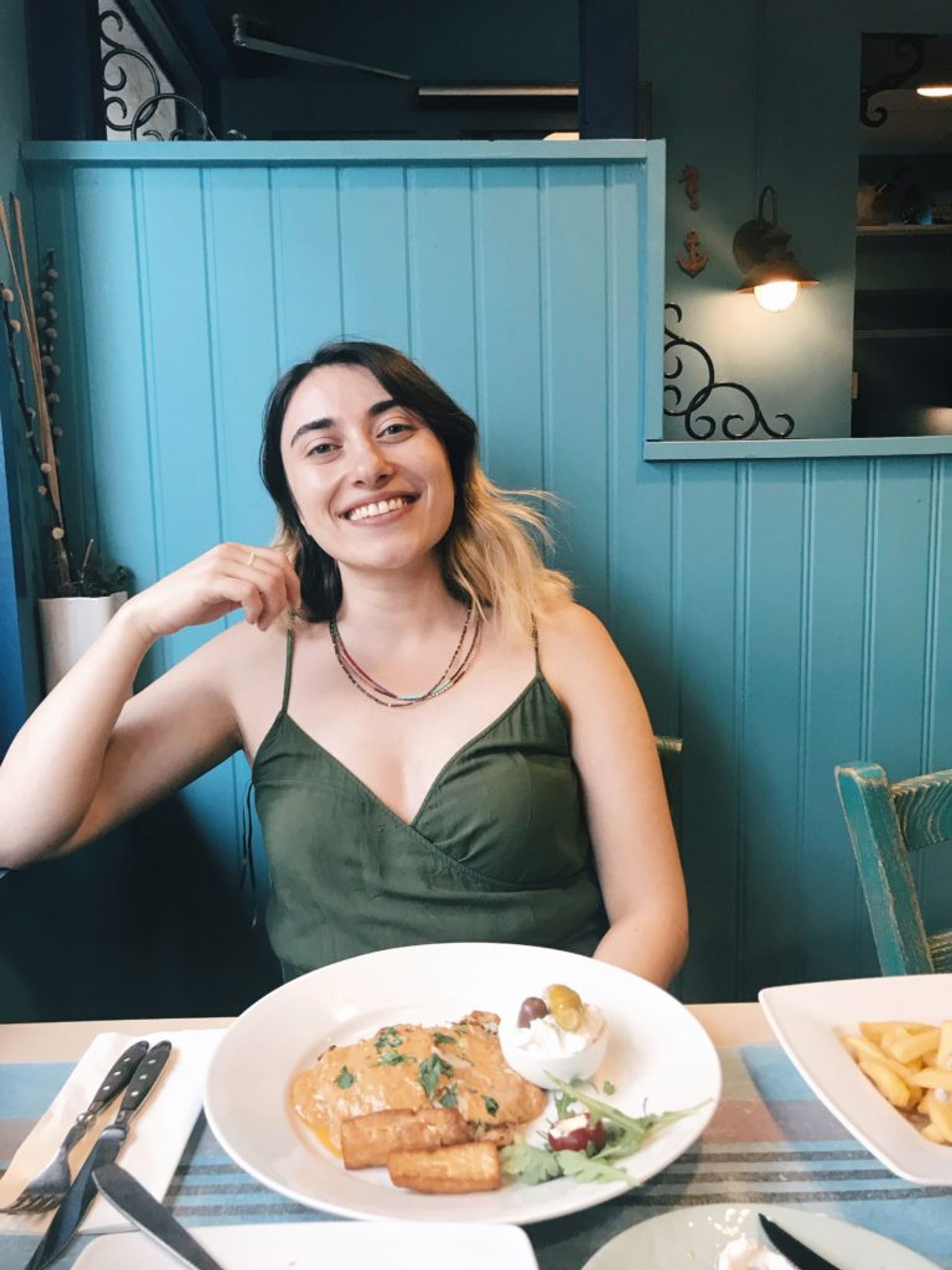 A student poses for a photo in a restaurant.