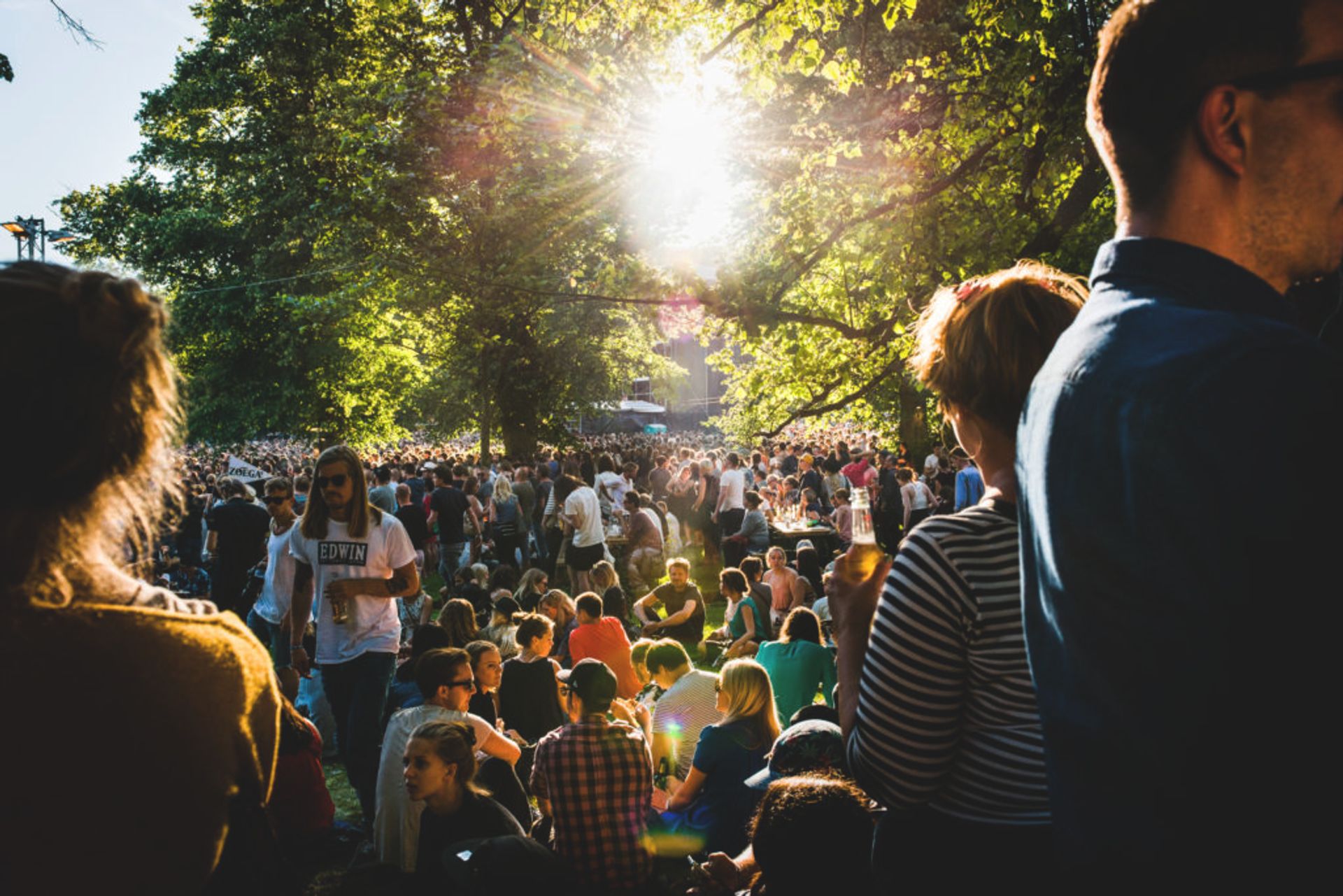 A park full of people watching a concert.