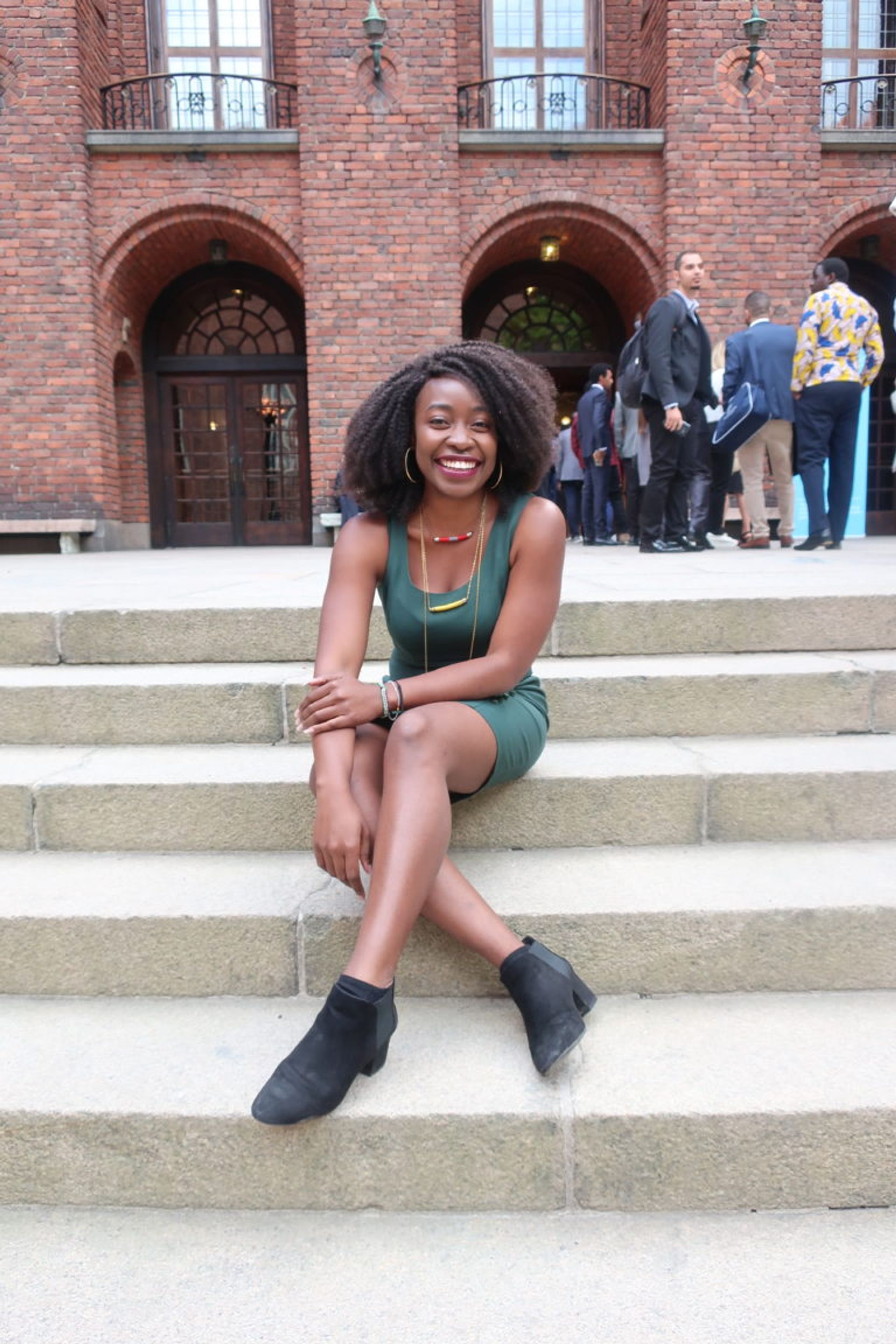 A students sits on steps outside a building.