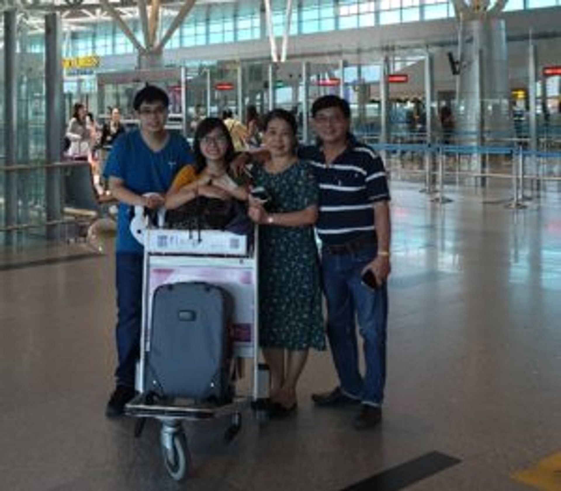 A family posing for a photo in an airport.