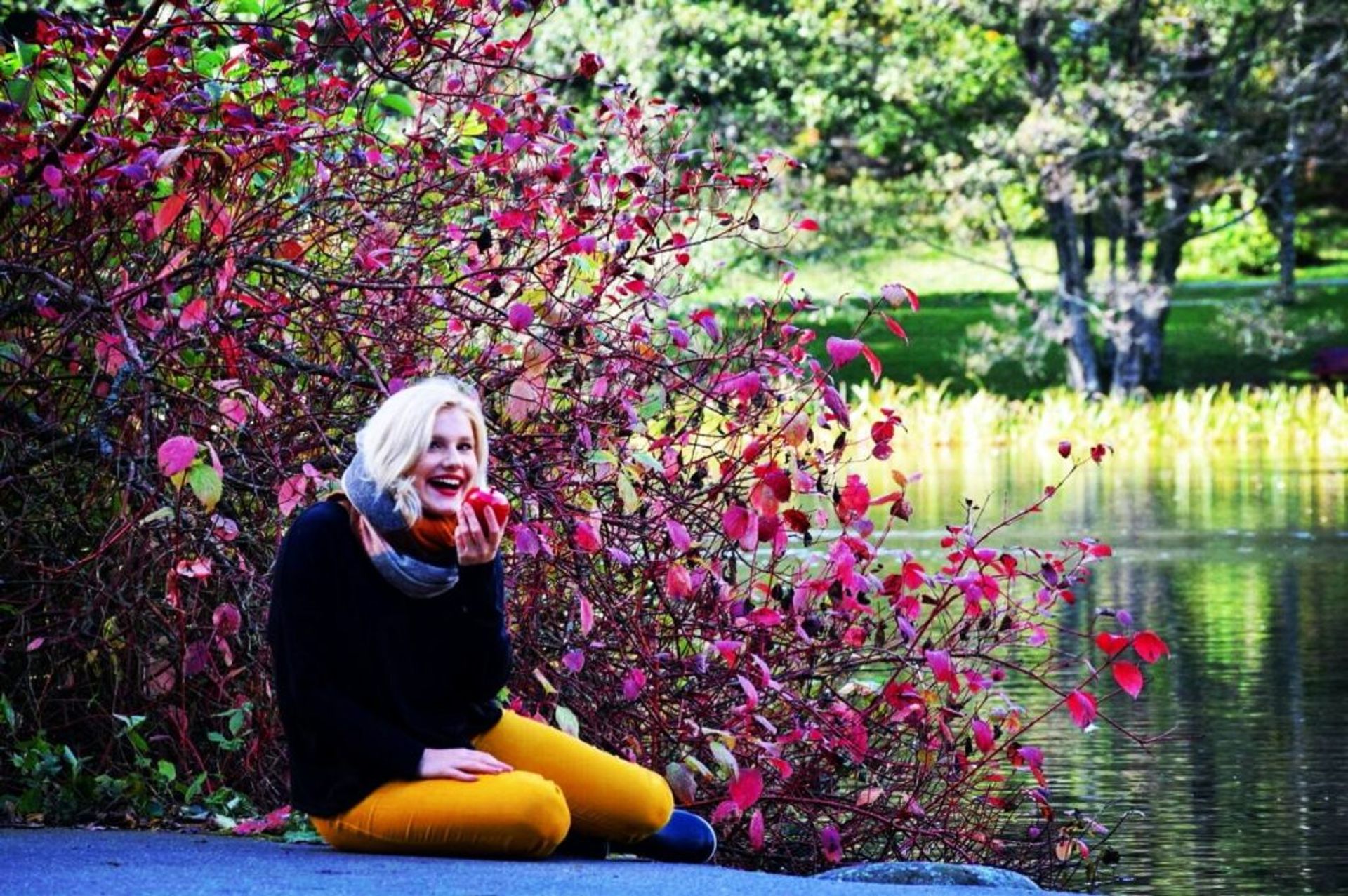 Student sitting beside a lake.